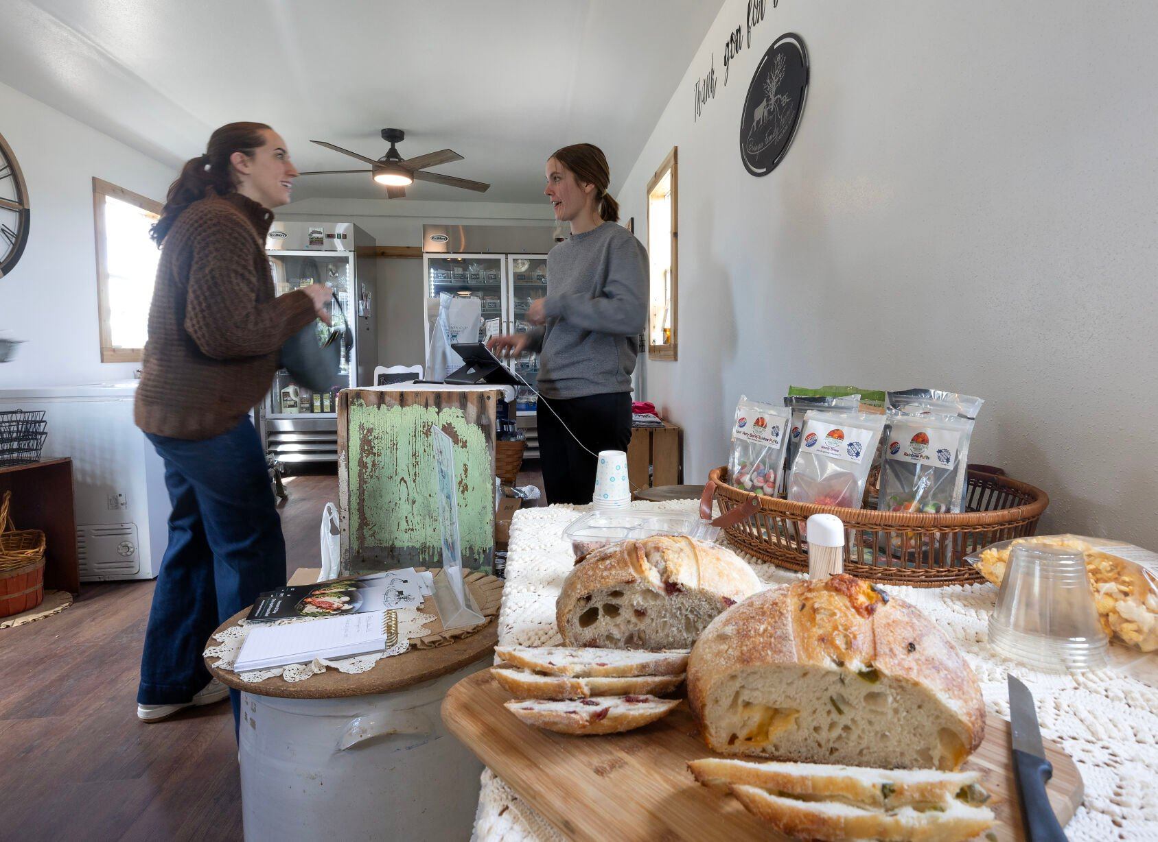 Lillie Beringer (right) waits on Sarah Knabel on Friday at Beringer Family Farms Store, which recently opened as a one-stop-shop farmers market on the family’s farm in Cascade, Iowa.    PHOTO CREDIT: Gassman