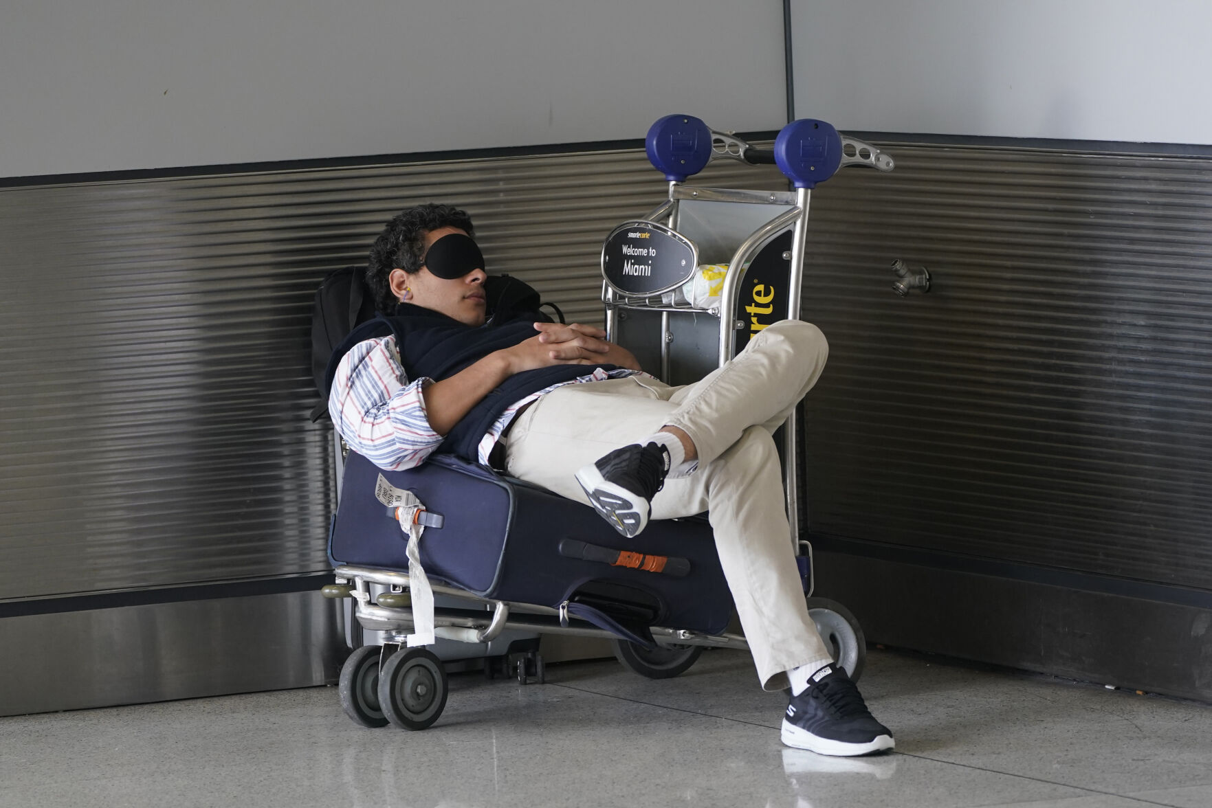 <p>FILE - A traveler takes a nap as he waits for a ride outside Miami International Airport, Friday, July 1, 2022, in Miami. The Gallup survey, released Monday, April 15, 2024, says that a majority of Americans say they would feel better if they could have more sleep. But in the U.S., where the ethos of grinding and pulling yourself up by your own bootstraps is ubiquitous, getting enough sleep can seem like a dream. (AP Photo/Wilfredo Lee, File)</p>   PHOTO CREDIT: Wilfredo Lee