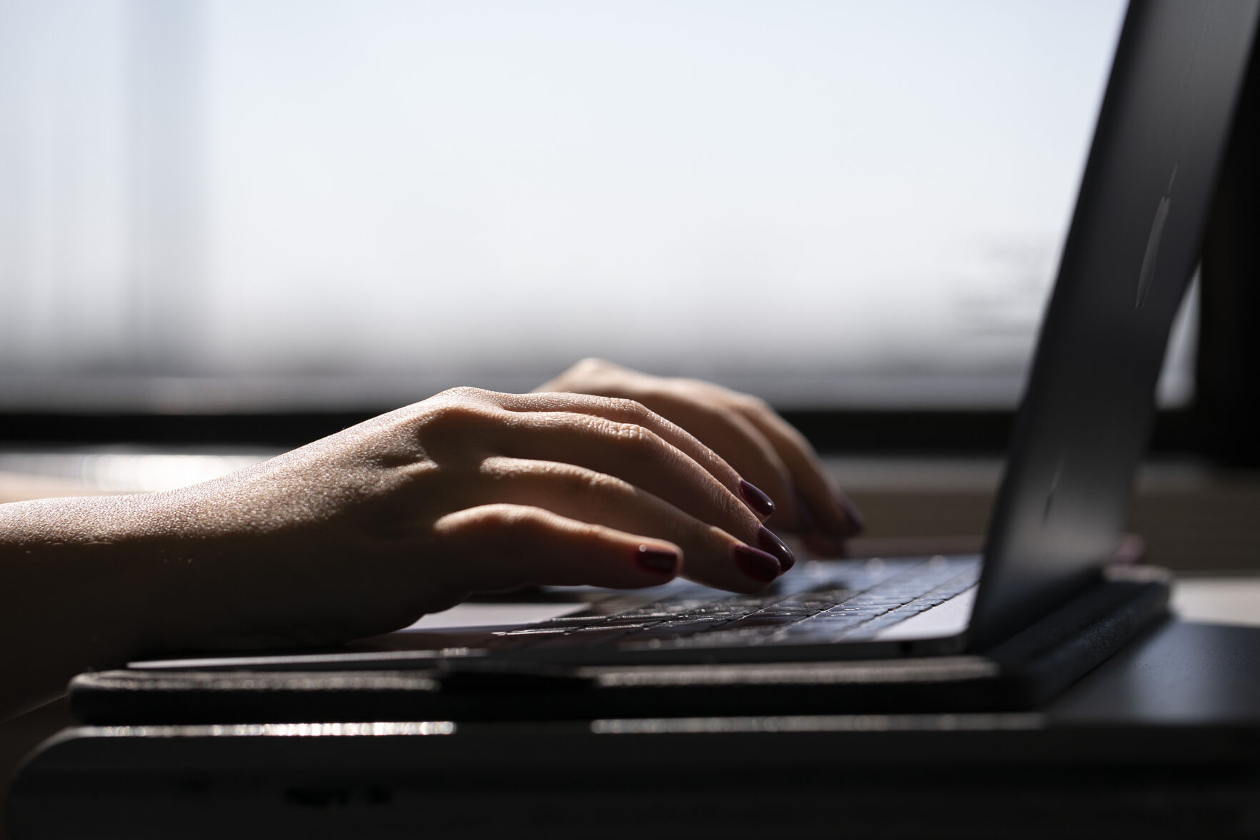 <p>FILE - This May 18, 2021, photo shows a woman typing on a laptop on a train in New Jersey. Record numbers of people are starting new businesses, and more and more of them are women and minorities, according to a new study. (AP Photo/Jenny Kane, File)</p>   PHOTO CREDIT: Jenny Kane - staff, ASSOCIATED PRESS