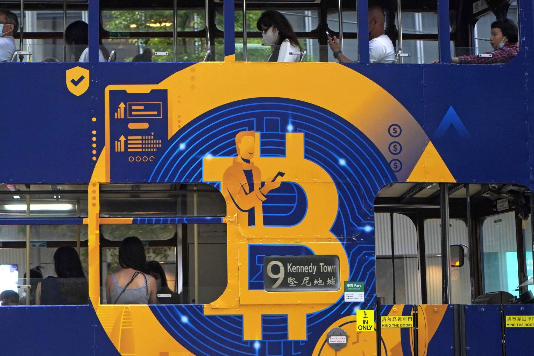 <p>FILE - An advertisement for the cryptocurrency Bitcoin displayed on a tram, May 12, 2021, in Hong Kong. Sometime in the next few days or even hours, the “miners” who chisel bitcoins out of complex mathematics are going to take a 50% pay cut — effectively slicing new emissions of the world’s largest cryptocurrency in an event called bitcoin halving. (AP Photo/Kin Cheung, File)</p>   PHOTO CREDIT: Kin Cheung - staff, ASSOCIATED PRESS