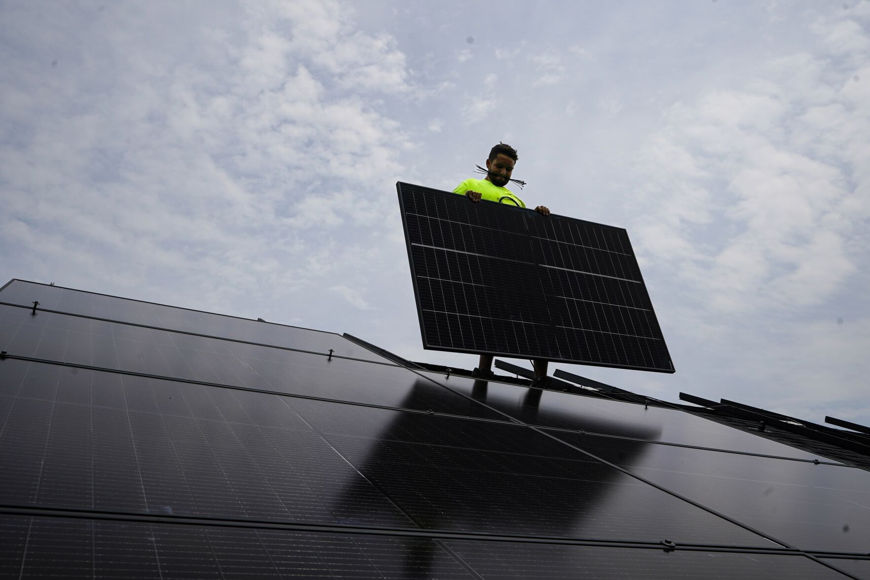 <p>FILE - Nicholas Hartnett, owner of Pure Power Solar, holds a panel as his company installs a solar array on the roof of a home in Frankfort, Ky., July 17, 2023. (AP Photo/Michael Conroy, File)</p>   PHOTO CREDIT: Michael Conroy 
