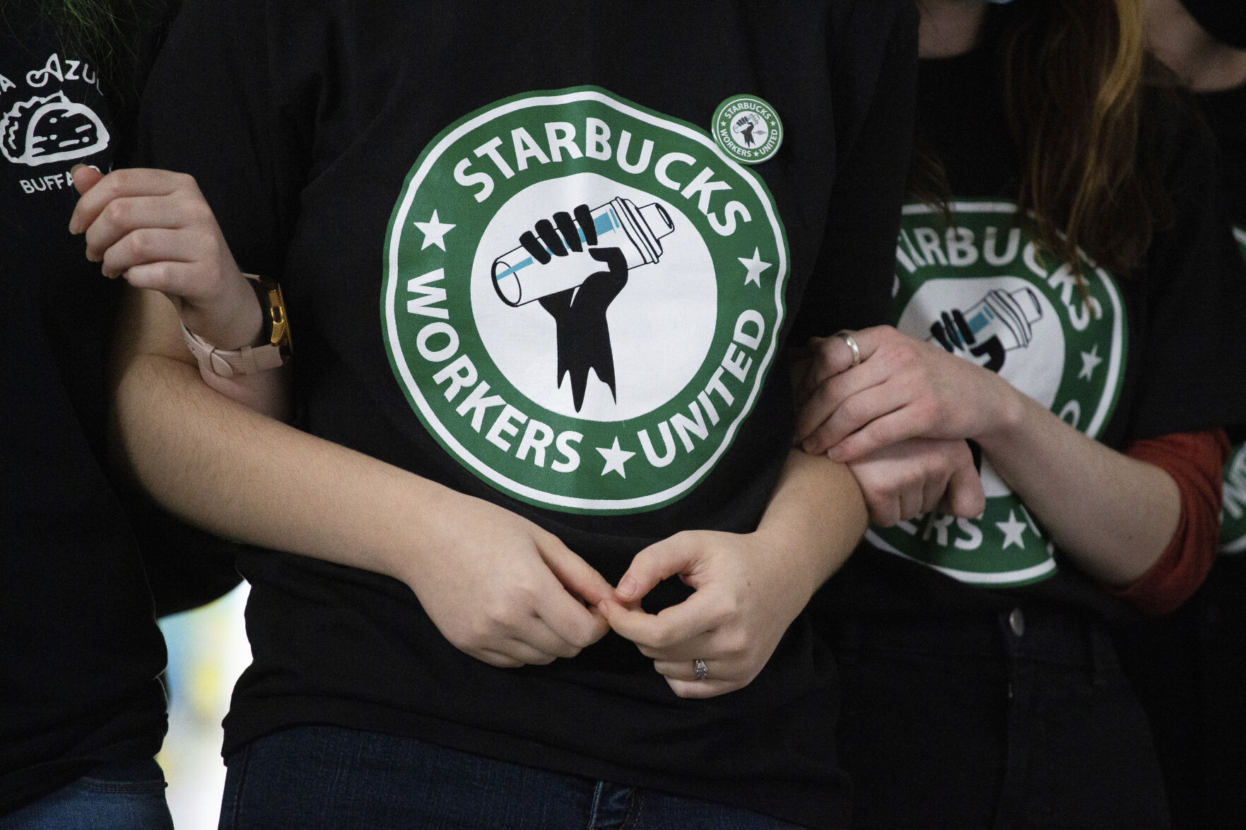 <p>FILE - Starbucks employees and supporters link arms during a union election watch party Dec. 9, 2021, in Buffalo, N.Y. The U.S. Supreme Court is set to hear oral arguments in a case filed by Starbucks against the National Labor Relations Board. (AP Photo/Joshua Bessex, File)</p>   PHOTO CREDIT: Joshua Bessex