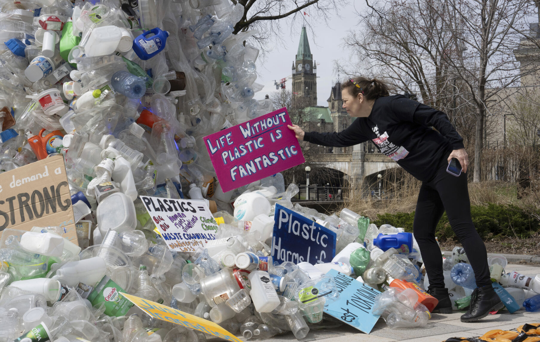<p>FILE - Activist Dianne Peterson places a sign on an art installation outside a United Nations conference on plastics, April 23, 2024, in Ottawa, Ontario. (Adrian Wyld/The Canadian Press via AP. File)</p>   PHOTO CREDIT: Adrian Wyld 