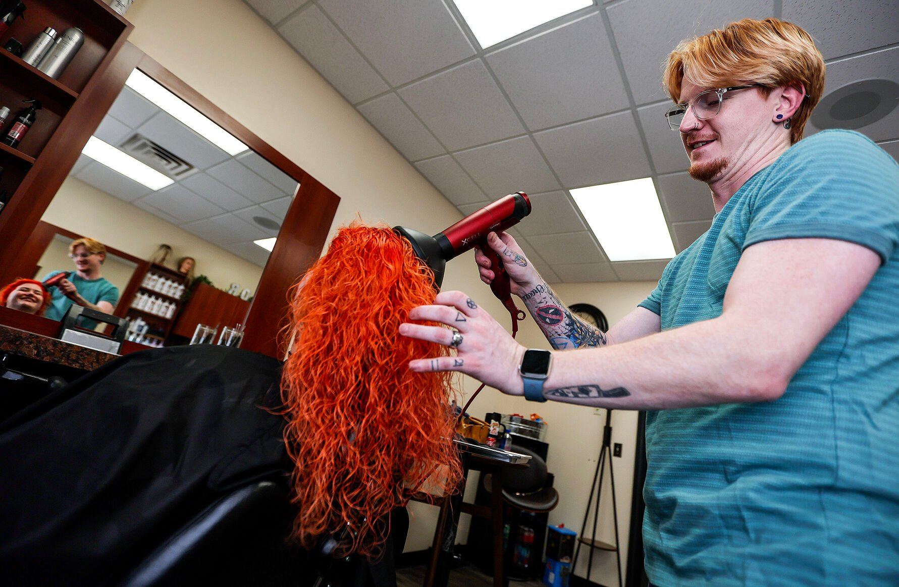 The Color Parlor owner Christopher Bellings works with client Dominique Grill, of Dyersville, Iowa, at the Dubuque salon on Friday.    PHOTO CREDIT: Dave Kettering