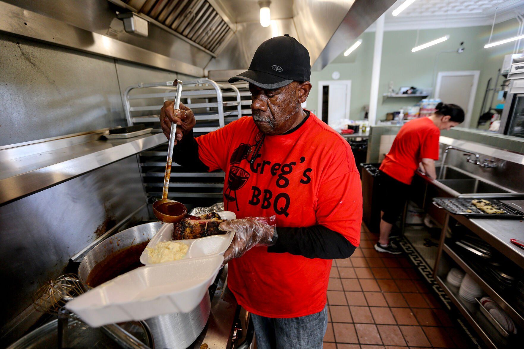 Greg Harrison, owner of Greg’s BBQ, prepares ribs at his business on Central Avenue in Dubuque on Thursday.    PHOTO CREDIT: Dave Kettering