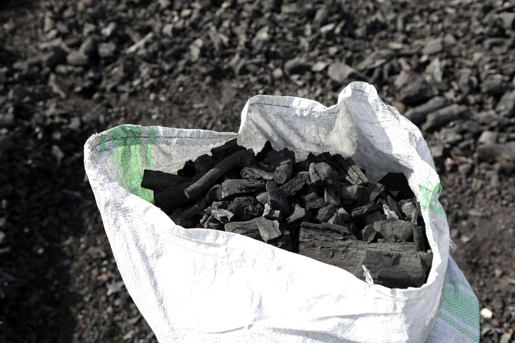 <p>FILE - A sack of charcoal is filled in Gulu, Uganda on May 27, 2023. (AP Photo/Hajarah Nalwadda, File)</p>   PHOTO CREDIT: Hajarah Nalwadda
