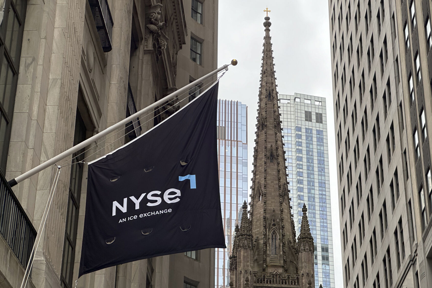 <p>FILE - A flag hangs from the side of the New York Stock Exchange is on Thursday, May 16, 2024, in New York. Trinity Church appears in the background. (AP Photo/Peter Morgan, File)</p>   PHOTO CREDIT: Peter Morgan - staff, ASSOCIATED PRESS