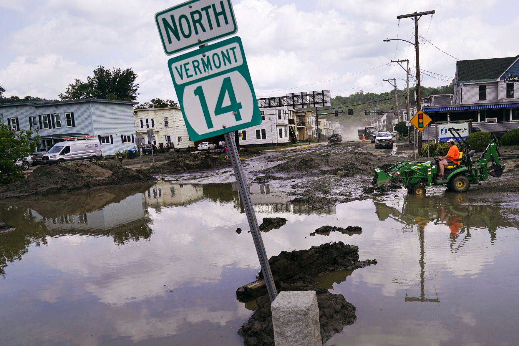 <p>FILE - A small tractor clears water from a business as flood waters block a street, July 12, 2023, in Barre, Vt. Vermont has become the first state to enact a law requiring fossil fuel companies to pay a share of the damage caused by climate change, Thursday, May 30, 2024, after the state suffered catastrophic summer flooding and damage from other extreme weather. (AP Photo/Charles Krupa, file)</p>   PHOTO CREDIT: Charles Krupa - staff, ASSOCIATED PRESS