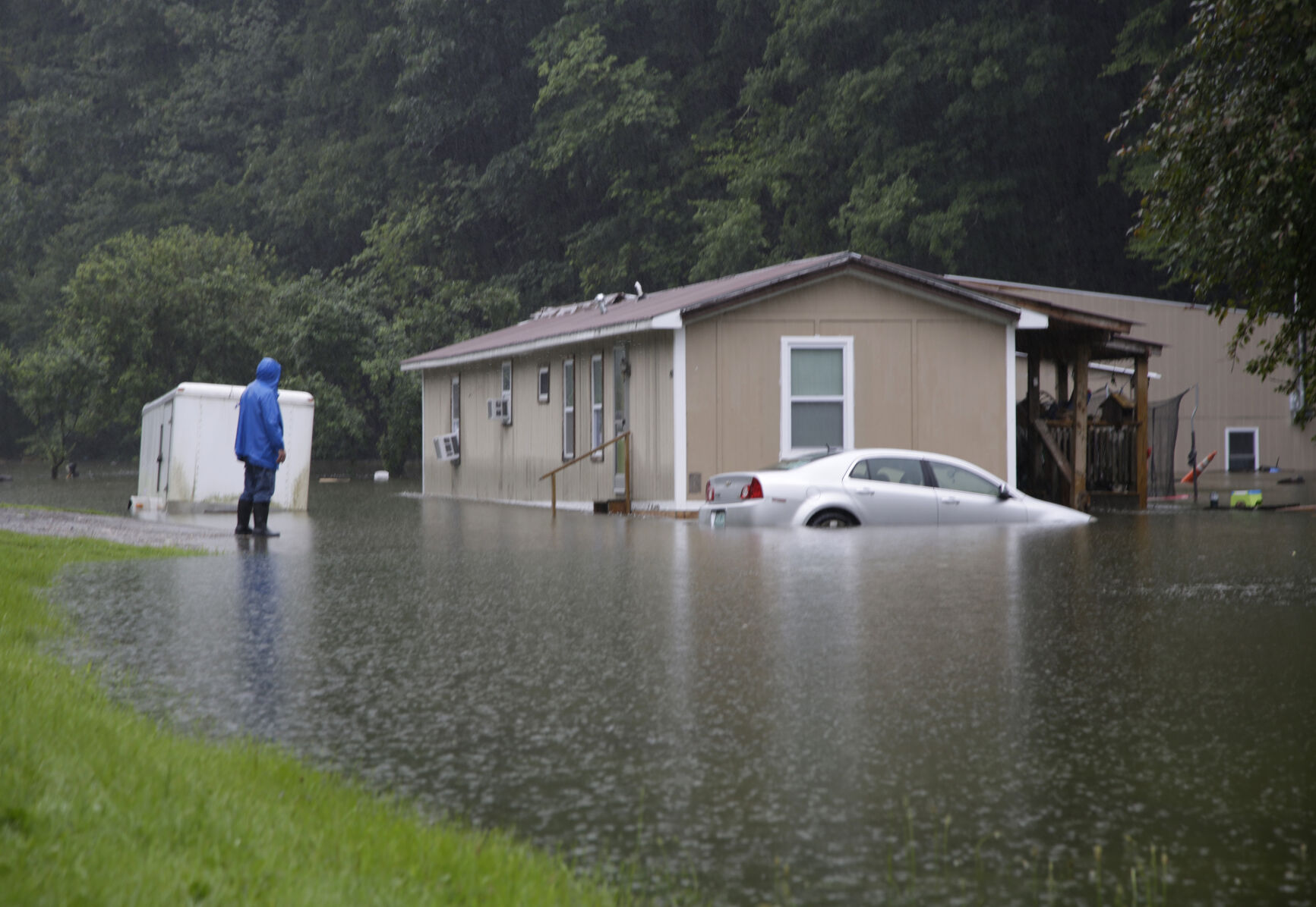 <p>FILE - A man views flood damage in Bridgewater, Vt., that submerged vehicles and threatened homes Monday, July 10, 2023. Vermont has become the first state to enact a law requiring fossil fuel companies to pay a share of the damage caused by climate change, Thursday, May 30, 2024 after the state suffered catastrophic summer flooding and damage from other extreme weather. (AP Photo/Hasan Jamali, File)</p>   PHOTO CREDIT: Hasan Jamali - freelancer, ASSOCIATED PRESS