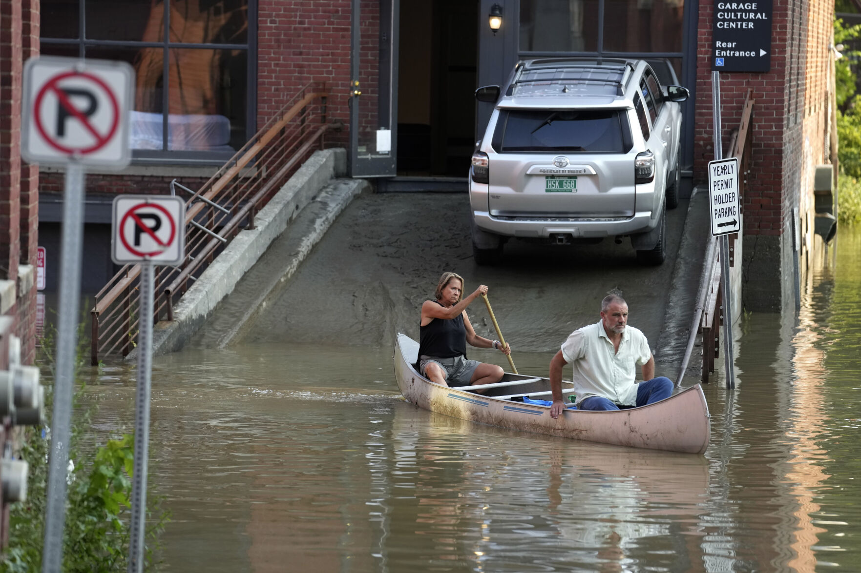 <p>FILE = Jodi Kelly, left, practice manager at Stonecliff Veterinary Surgical Center, behind, and her husband, veterinarian Dan Kelly, use a canoe to remove surgical supplies from the flood-damaged center, Tuesday, July 11, 2023, in Montpelier, Vt. Vermont has become the first state to enact a law requiring fossil fuel companies to pay a share of the damage caused by climate change, Thursday, May 30, 2024, after the state suffered catastrophic summer flooding and damage from other extreme weather. (AP Photo/Steven Senne, File)</p>   PHOTO CREDIT: Steven Senne - staff, ASSOCIATED PRESS