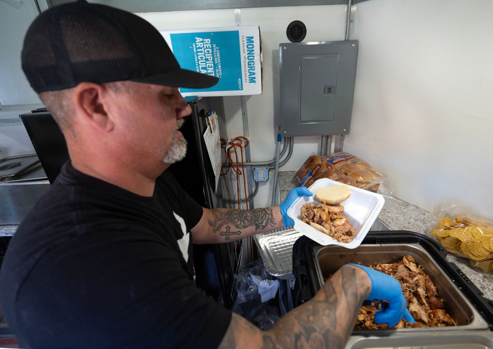 Owner Brice Morris prepares a sandwich inside Moski’s BBQ food truck while parked in Guttenberg, Iowa, on Wednesday, May 29, 2024.    PHOTO CREDIT: Gassman