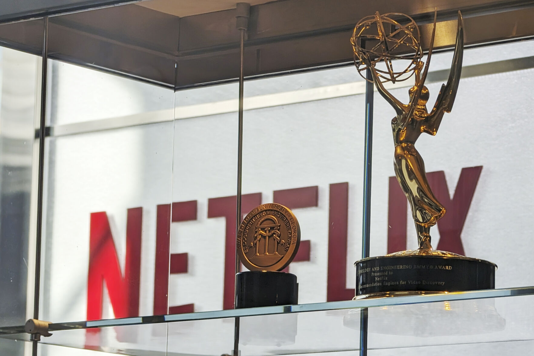 Awards, including an Emmy, are displayed at Netflix headquarters Los Gatos, Calif. on March 7, 2024. Netflix wins awards for its shows like a Hollywood studio, but still relies on the sophisticated technology of a Silicon Valley company to reel in viewers and subscribers. (AP Photo/Mike Liedtke)    PHOTO CREDIT: Associated Press