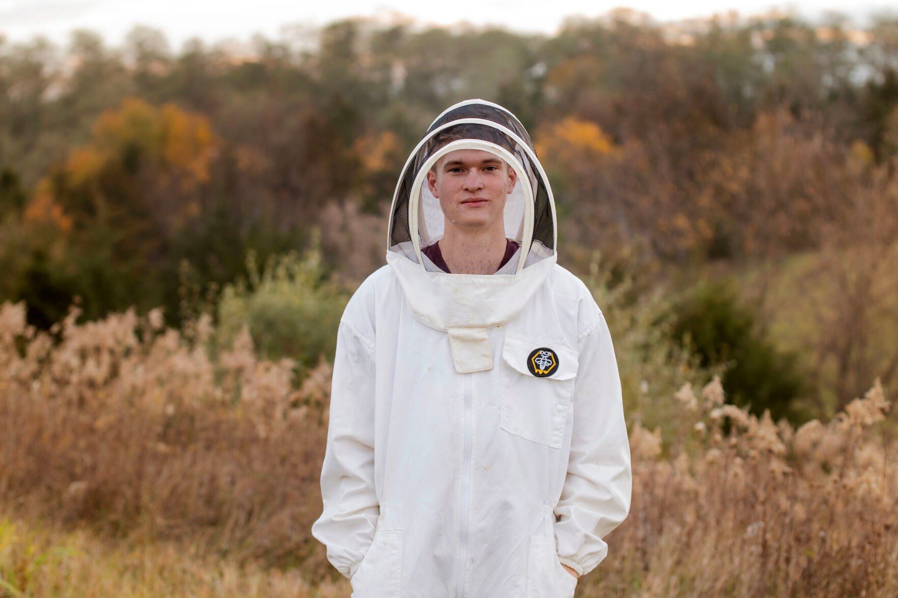 Chase Dittmar stands in his beekeeping suit used to care for one dozen hives across the Galena Territory. Dittmar runs Dry Creek Beekeeping and has been involved with bees since he was 13.    PHOTO CREDIT: Contributed