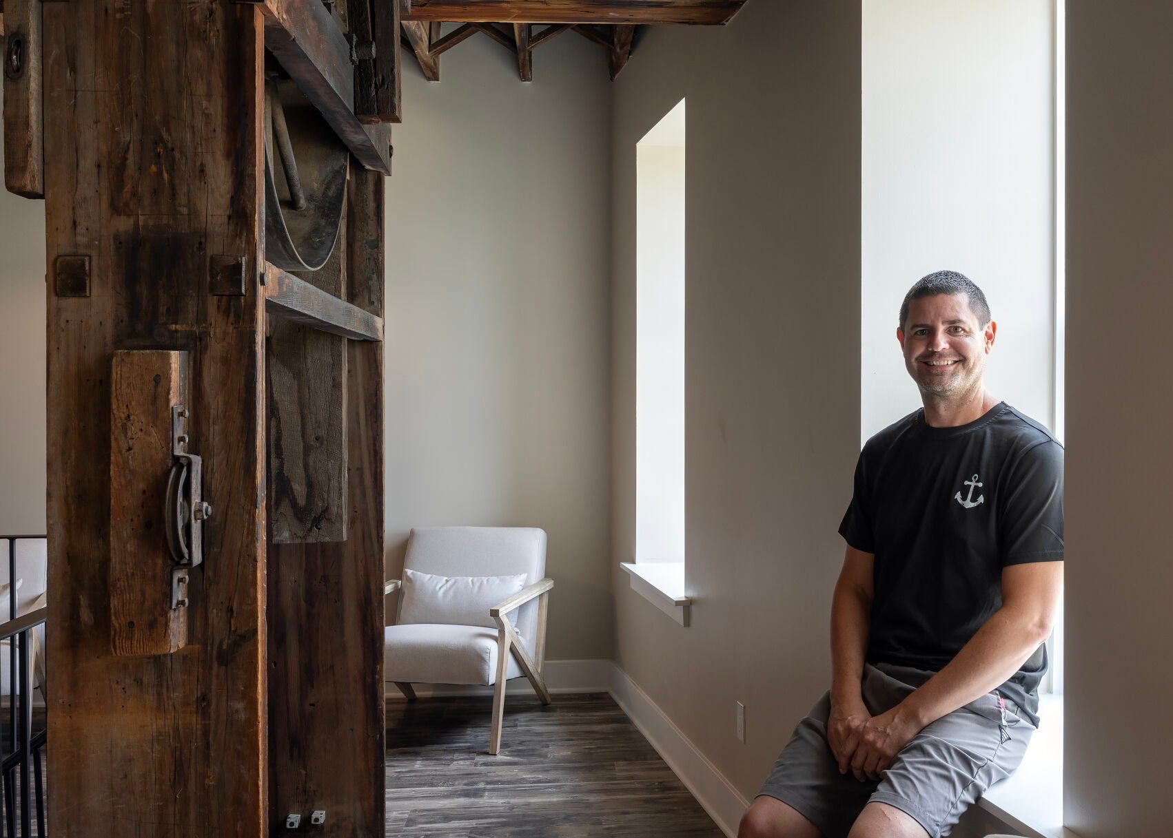 Owner Dan Blitgen sits in one of the common areas at River Rock Inn in Bellevue, Iowa, on Friday.    PHOTO CREDIT: Gassman