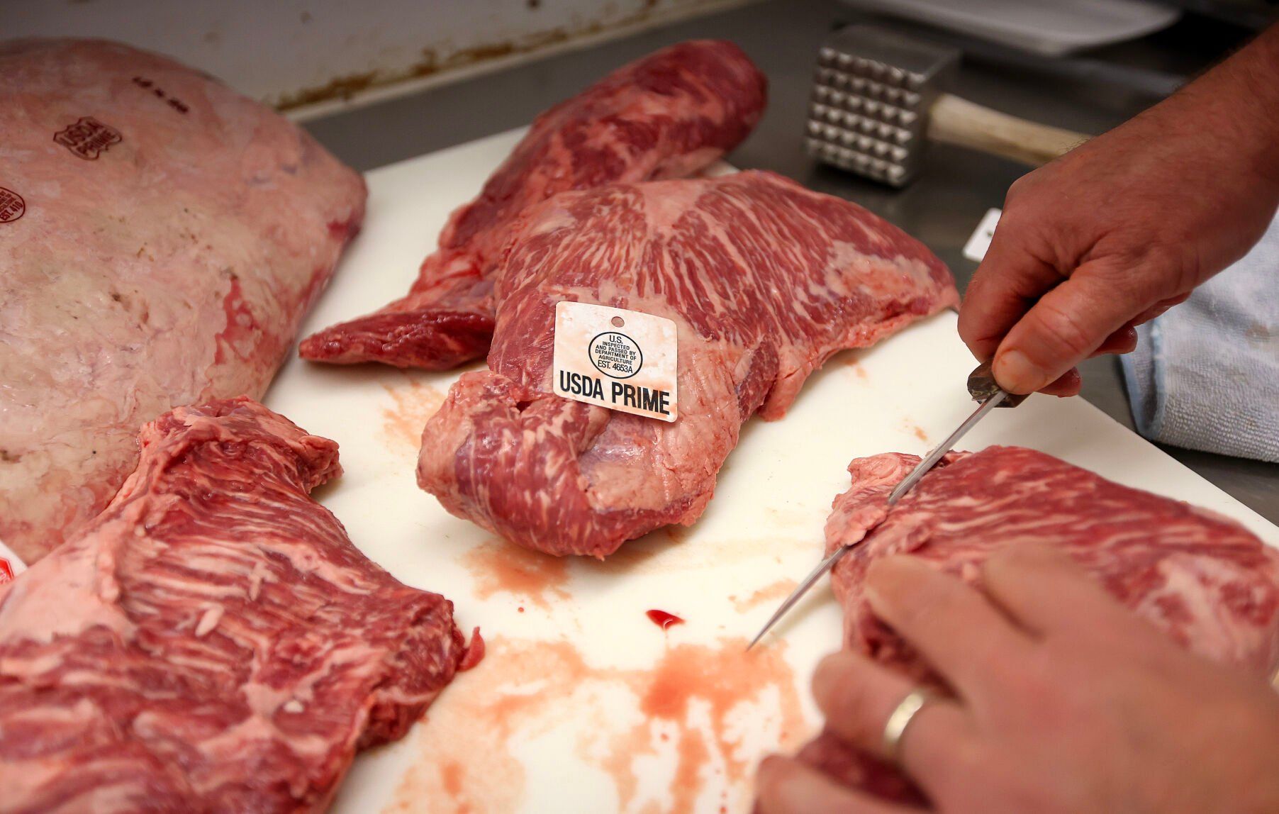 Jeff Cremer, of Cremer’s Grocery, says the marbling in the meat is something to look for when shopping for a quality steak.    PHOTO CREDIT: Dave Kettering/Telegraph Herald