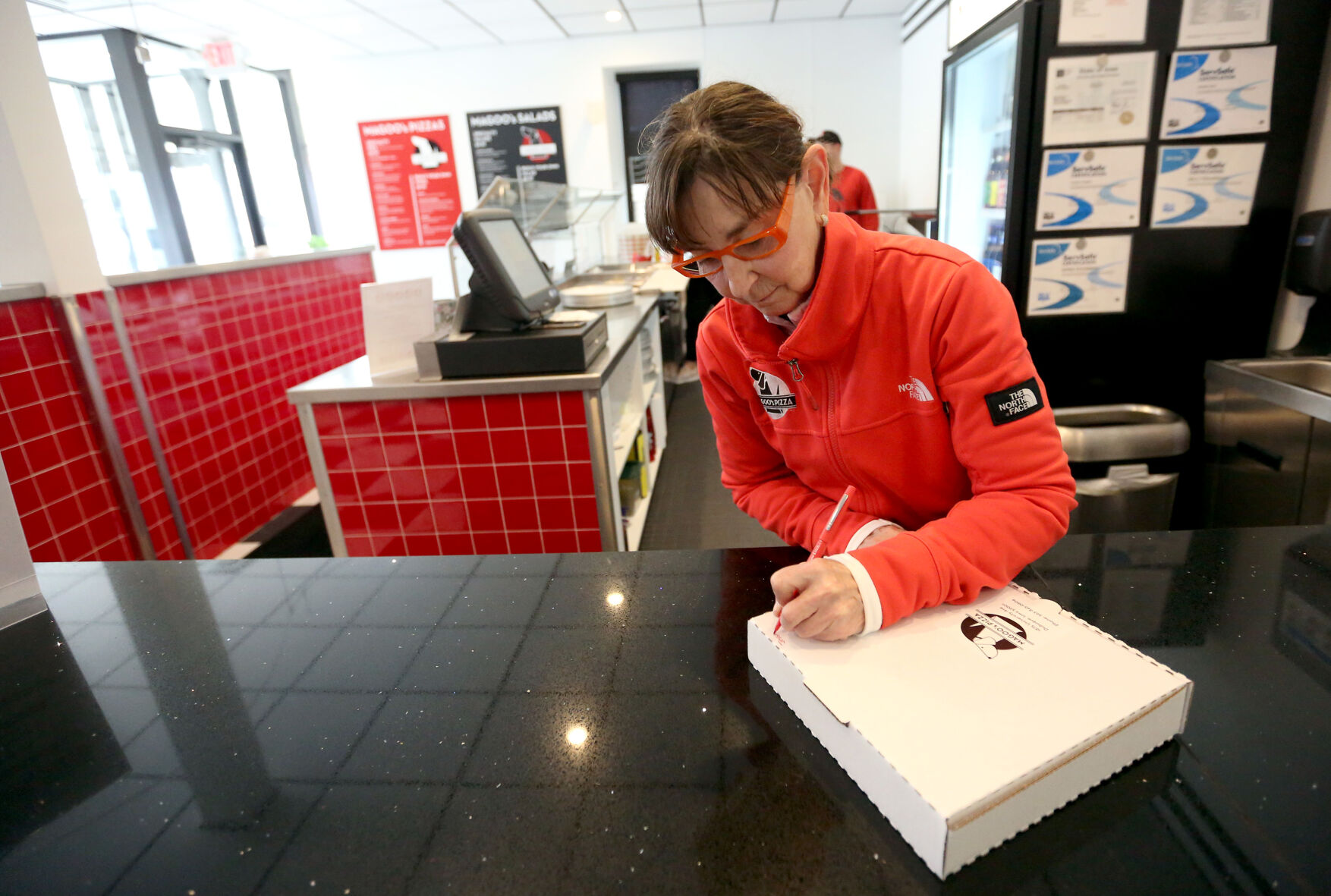 Susan Farber prepares an order at Magoo’s Pizza in Dubuque on Friday, March 20, 2020.    PHOTO CREDIT: File photo