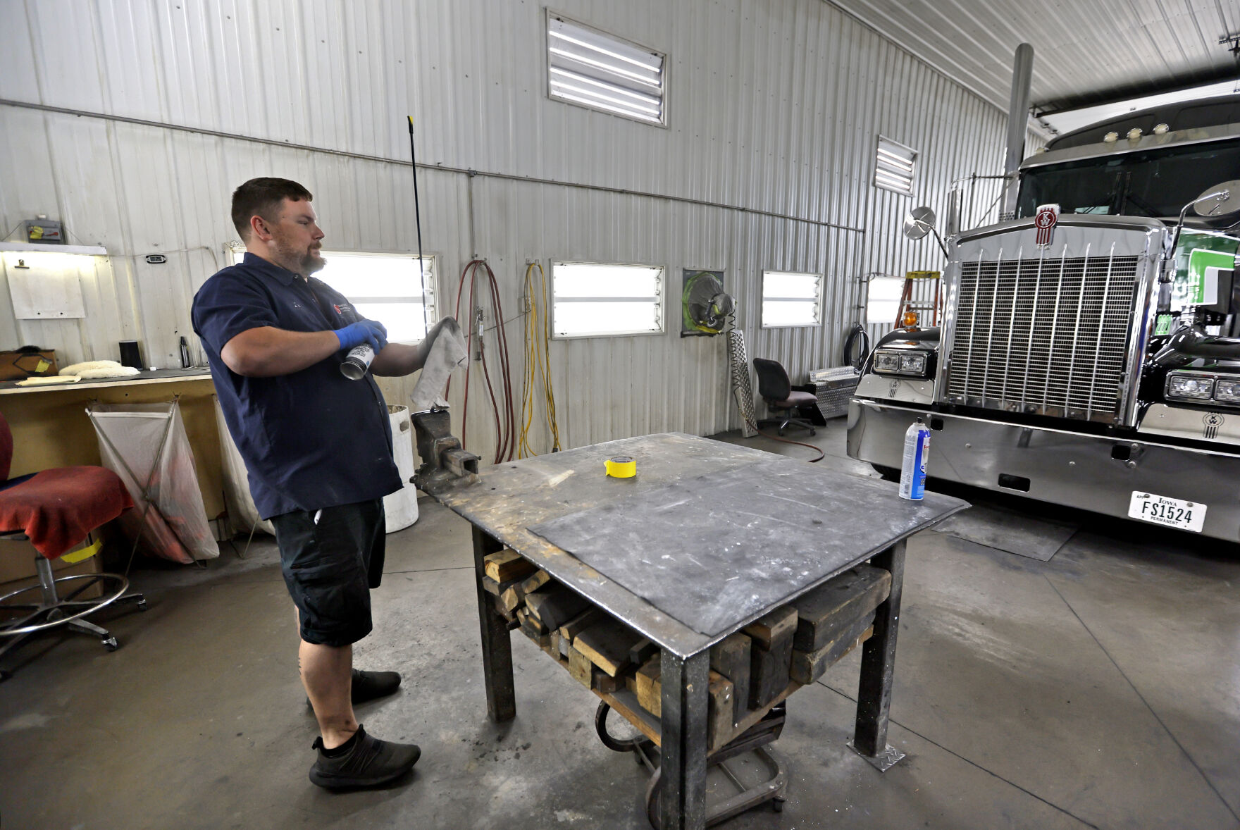 Employee Ian Rupe works on detailing a truck.    PHOTO CREDIT: File photo