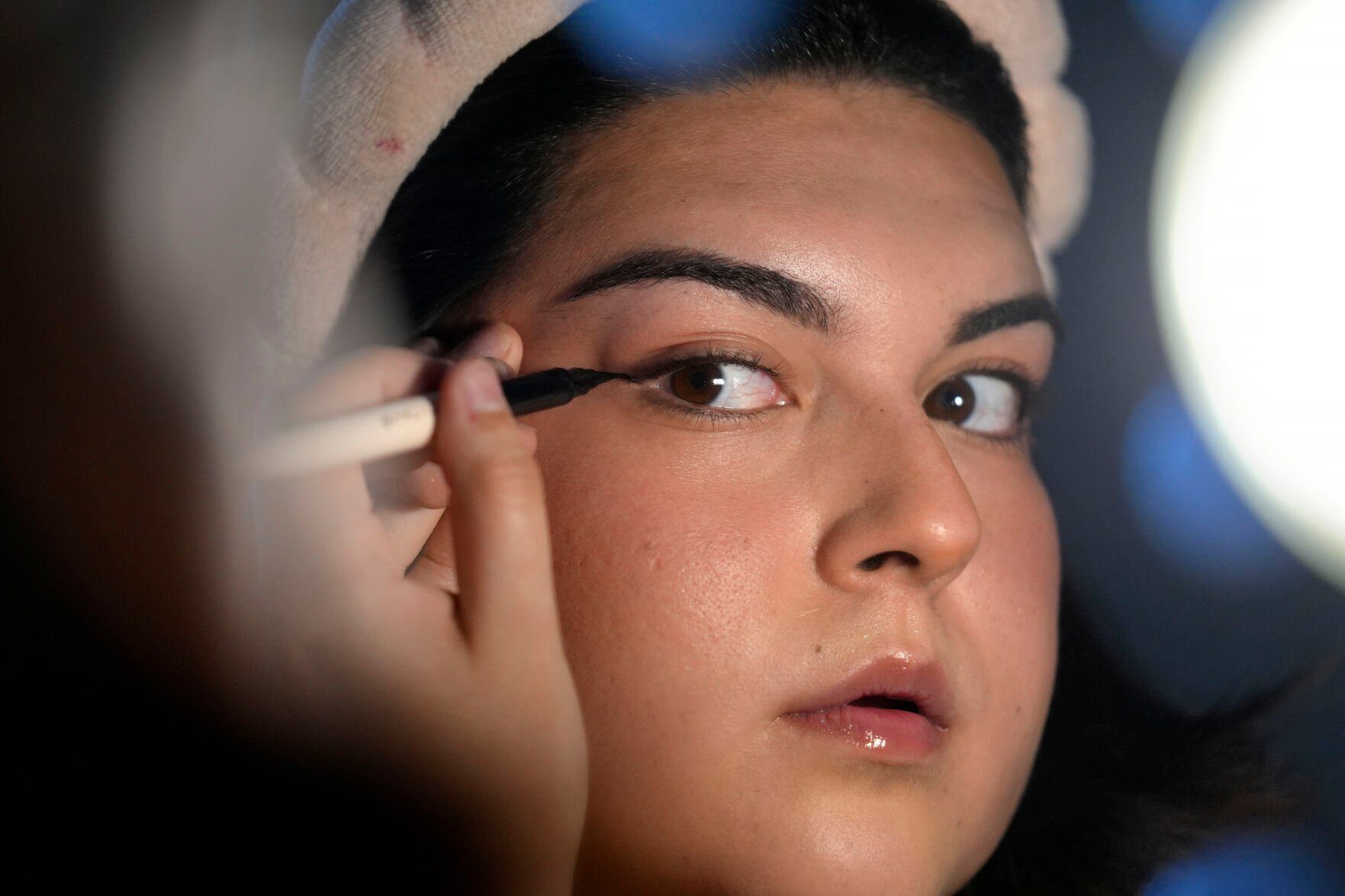 <p>Daniella López White, of Hawaii, uses a mirror while applying makeup, Tuesday, May 14, 2024, at her apartment in Boston. López White, who graduated from Emerson College in Boston this month and is on a tight budget, said TikTok influencers have helped her with tips on how to find affordable clothes at places like H&M and thrift shops. She buys makeup brands at CVS based on influencer advice. (AP Photo/Steven Senne)</p>   PHOTO CREDIT: Steven Senne 