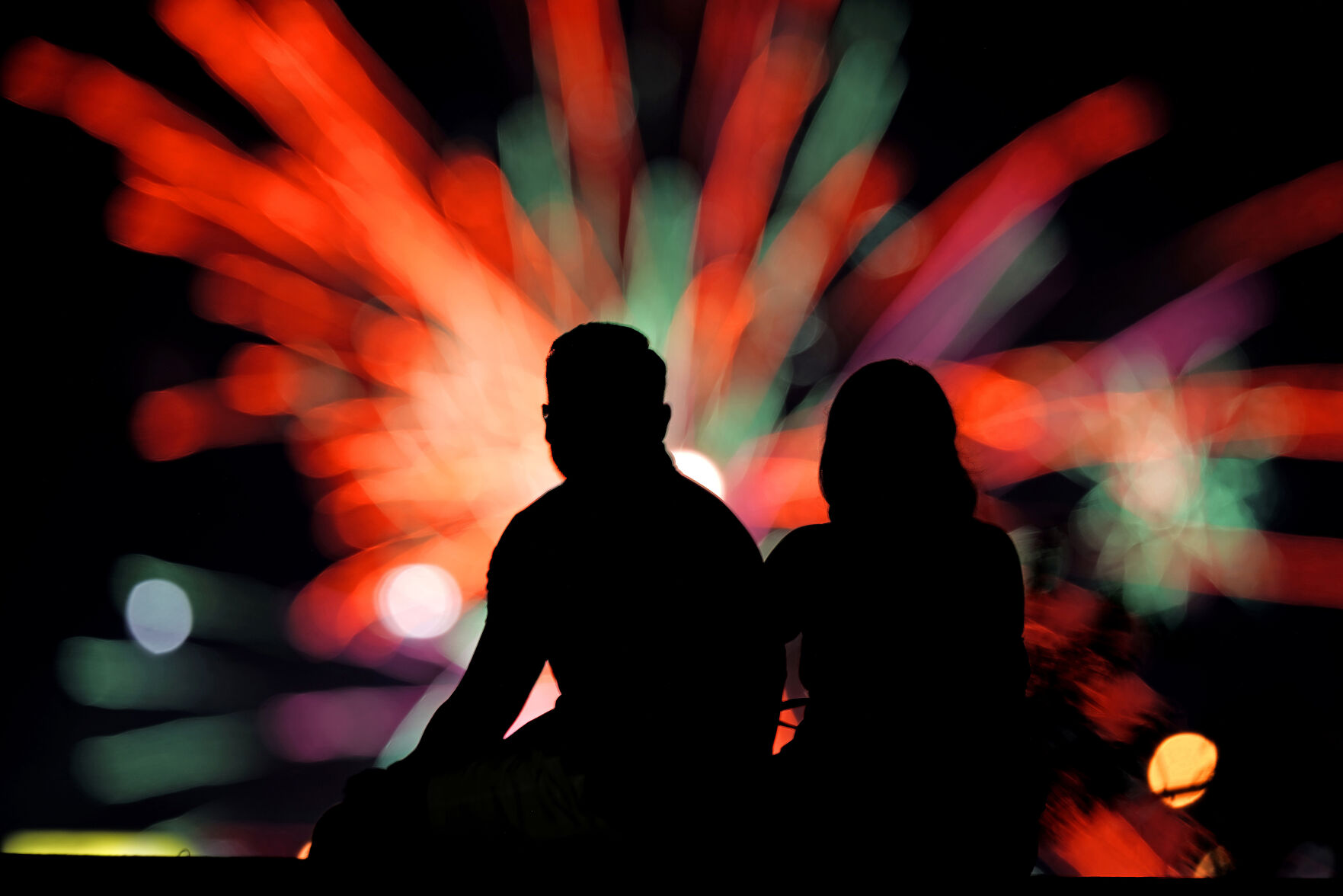 <p>FILE - People watch distant fireworks from a park on July 4, 2022, in Kansas City, Mo. Warehouse membership club Costco said it would be closed on July 4th, 2024, but the vast majority of major national retailers will be open, with some offering promotional sales to lure customers. (AP Photo/Charlie Riedel, File)</p>   PHOTO CREDIT: Charlie Riedel 