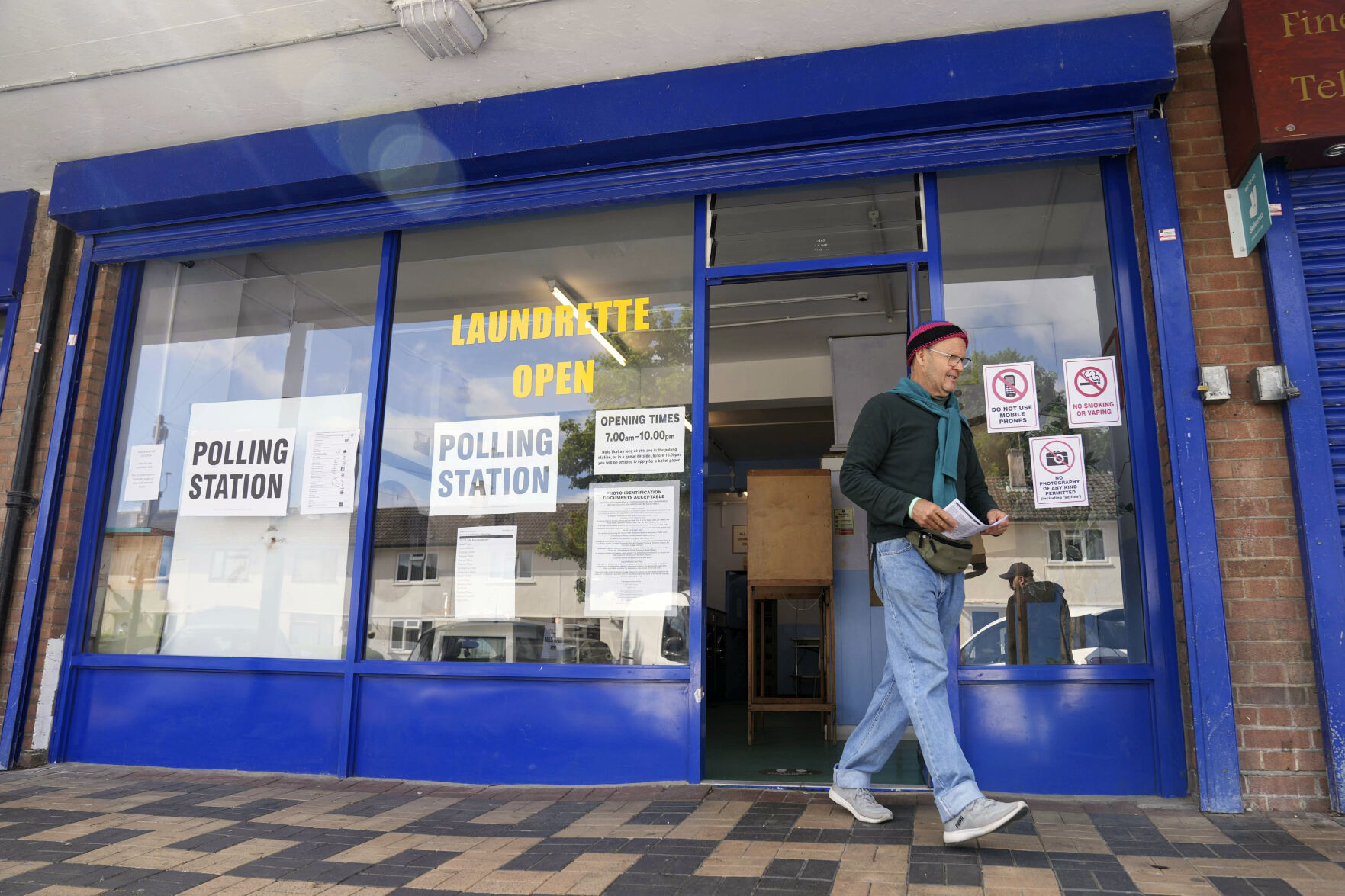 A man leaves after casting his ballot at a polling station installed inside a launderette for the 2024 General Election, in Oxford, England, Thursday July 4, 2024. (Jacob King/PA via AP)    PHOTO CREDIT: Associated Press