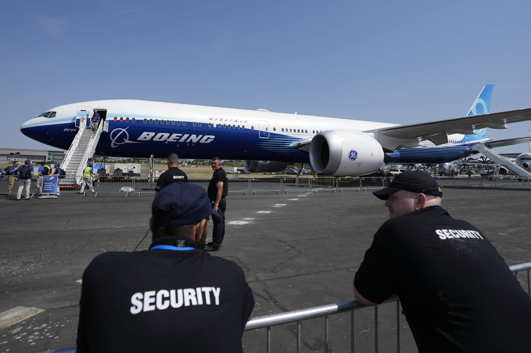 <p>FILE - Security members watch a Boeing 777 at the Farnborough Air Show fair in Farnborough, England, July 18, 2022. An ongoing safety and manufacturing crisis has Boeing keeping a lower profile at the 2024 Farnborough International Air Show, which kicks off Monday in England. (AP Photo/Frank Augstein, File)</p>   PHOTO CREDIT: Frank Augstein 