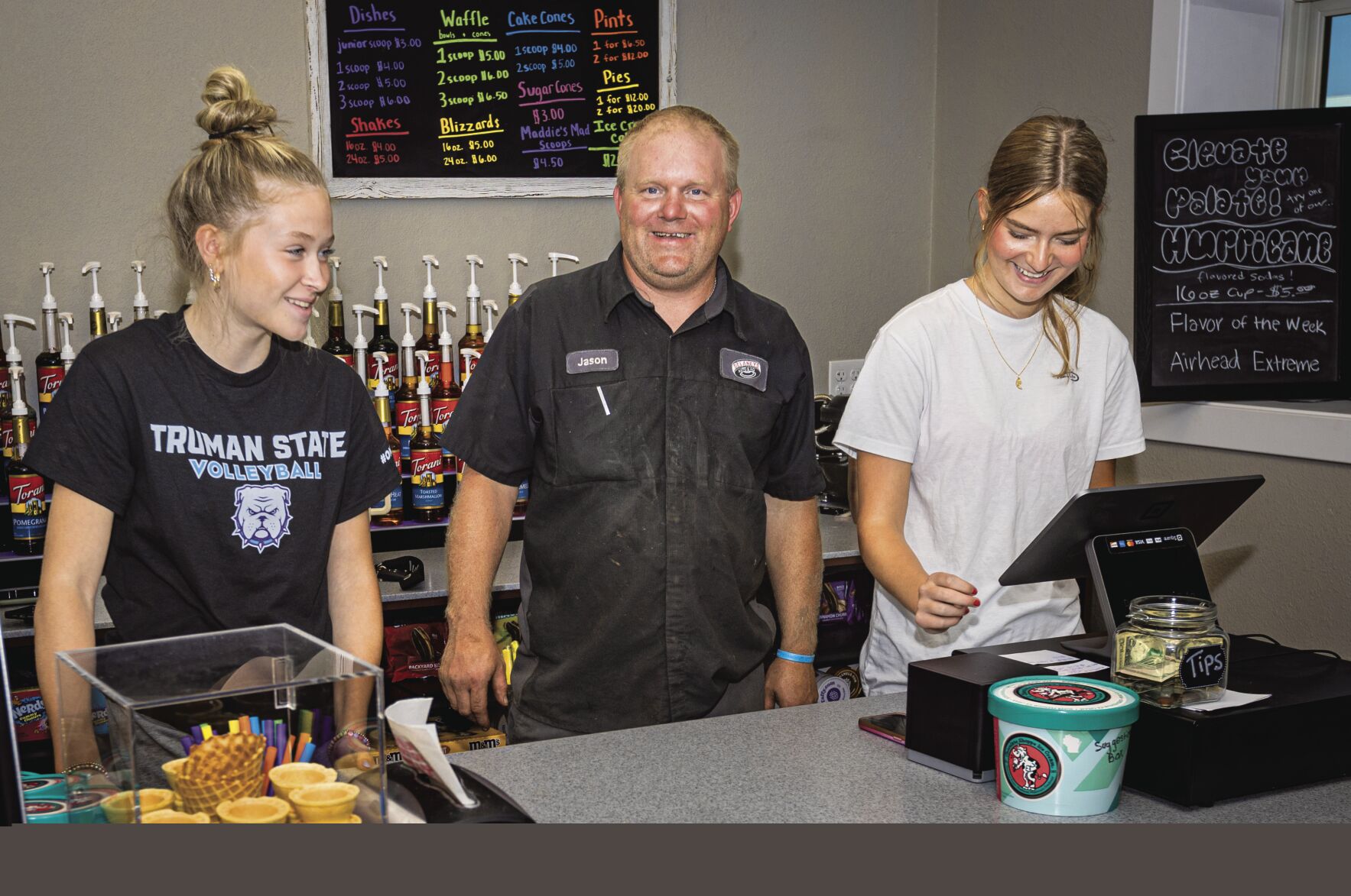 Jason Delaney takes a break from his auto shop to check on Brooklyn Trumm (left) and Mylie Miller at the newly opened Delaney