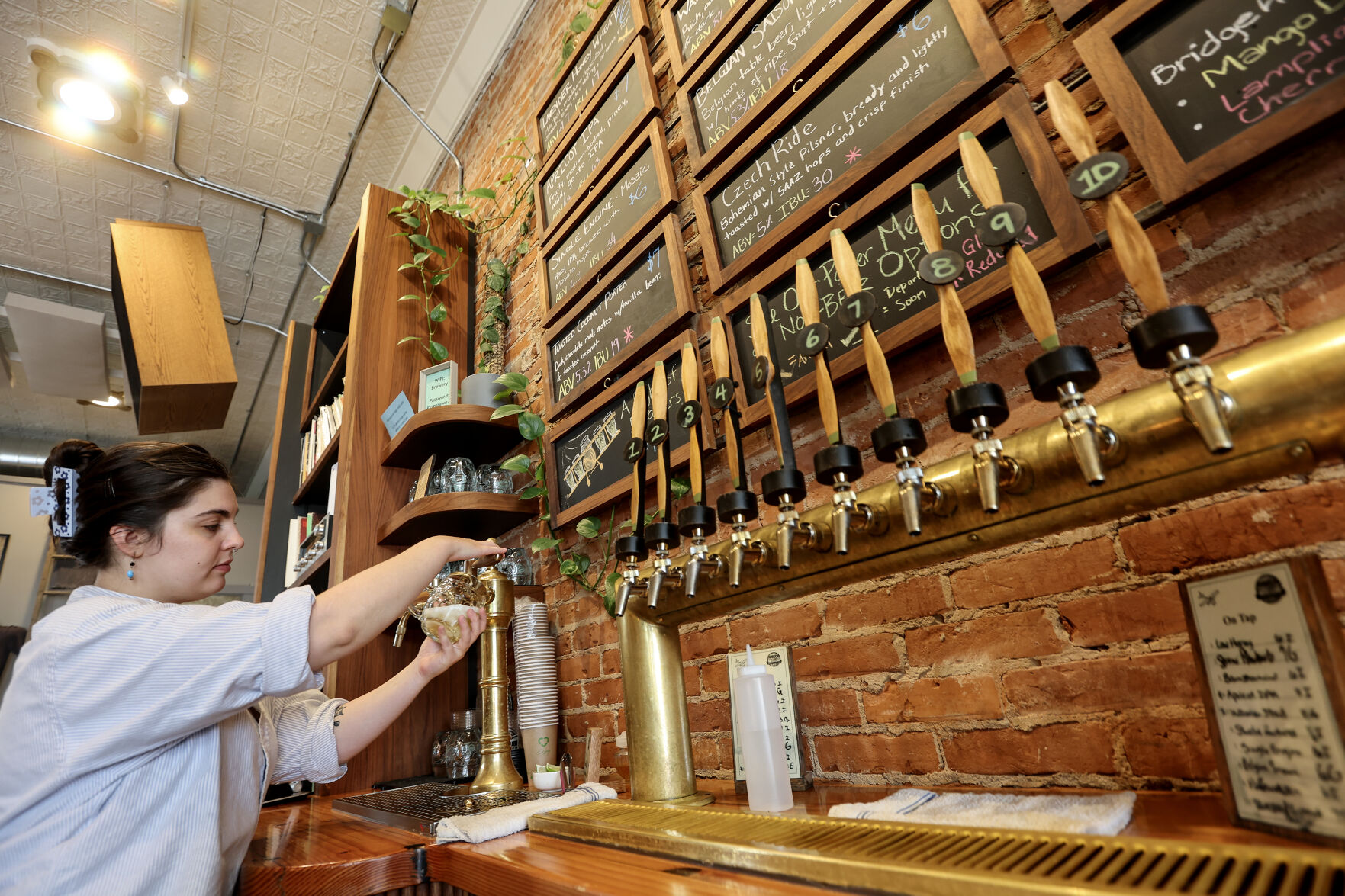 Shea Malloy draws a locally crafted beer for a customer at Jubeck New World Brewing.    PHOTO CREDIT: Dave Kettering