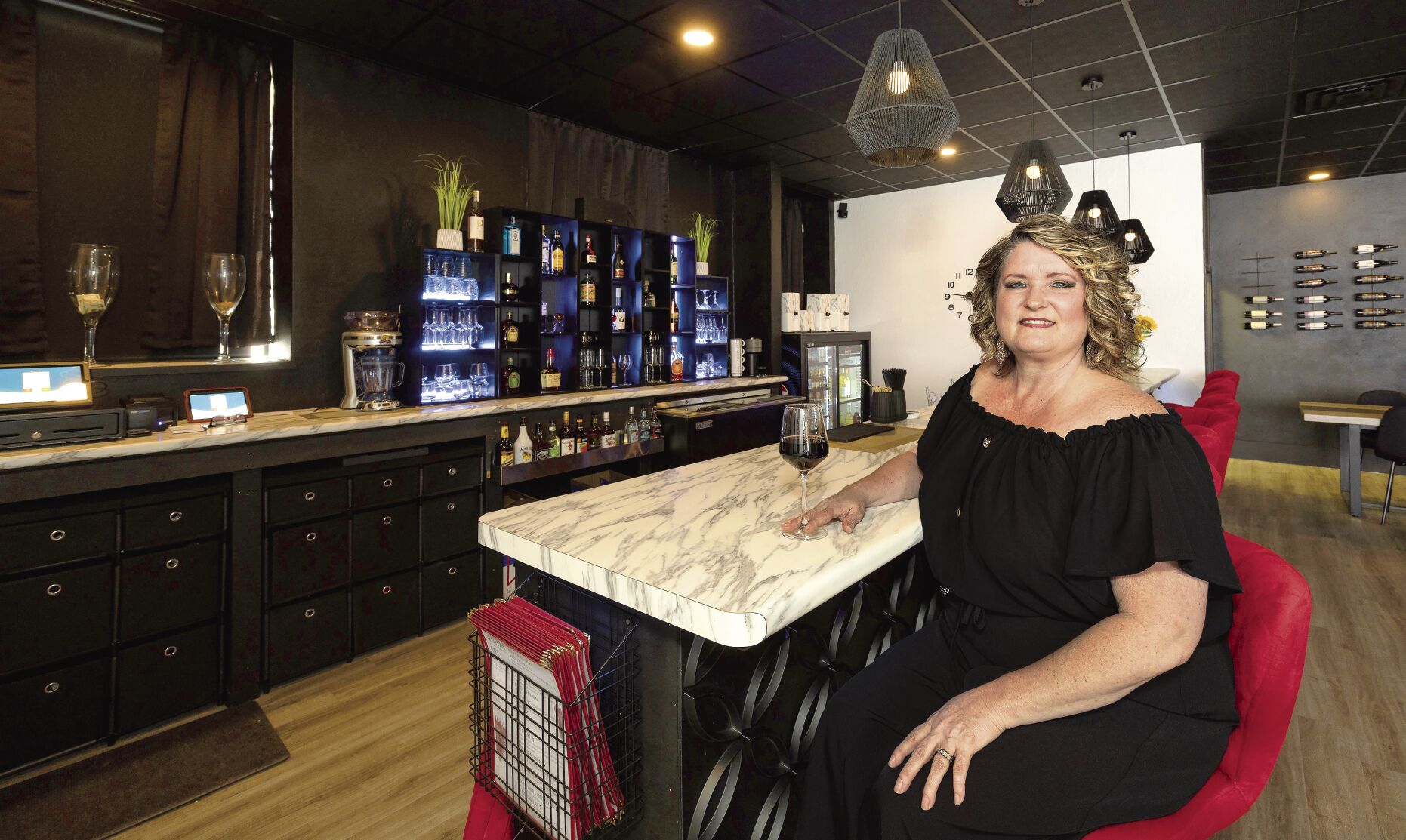 Owner Dulcie Mangold sits at the bar inside Dolce Vita Wine Bistro in Manchester, Iowa.    PHOTO CREDIT: Stephen Gassman