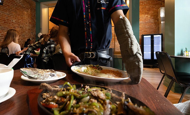 A server brings a plate of food to a customer at the Las Margarritas restaurant in Dubuque.    PHOTO CREDIT: Stephen Gassman