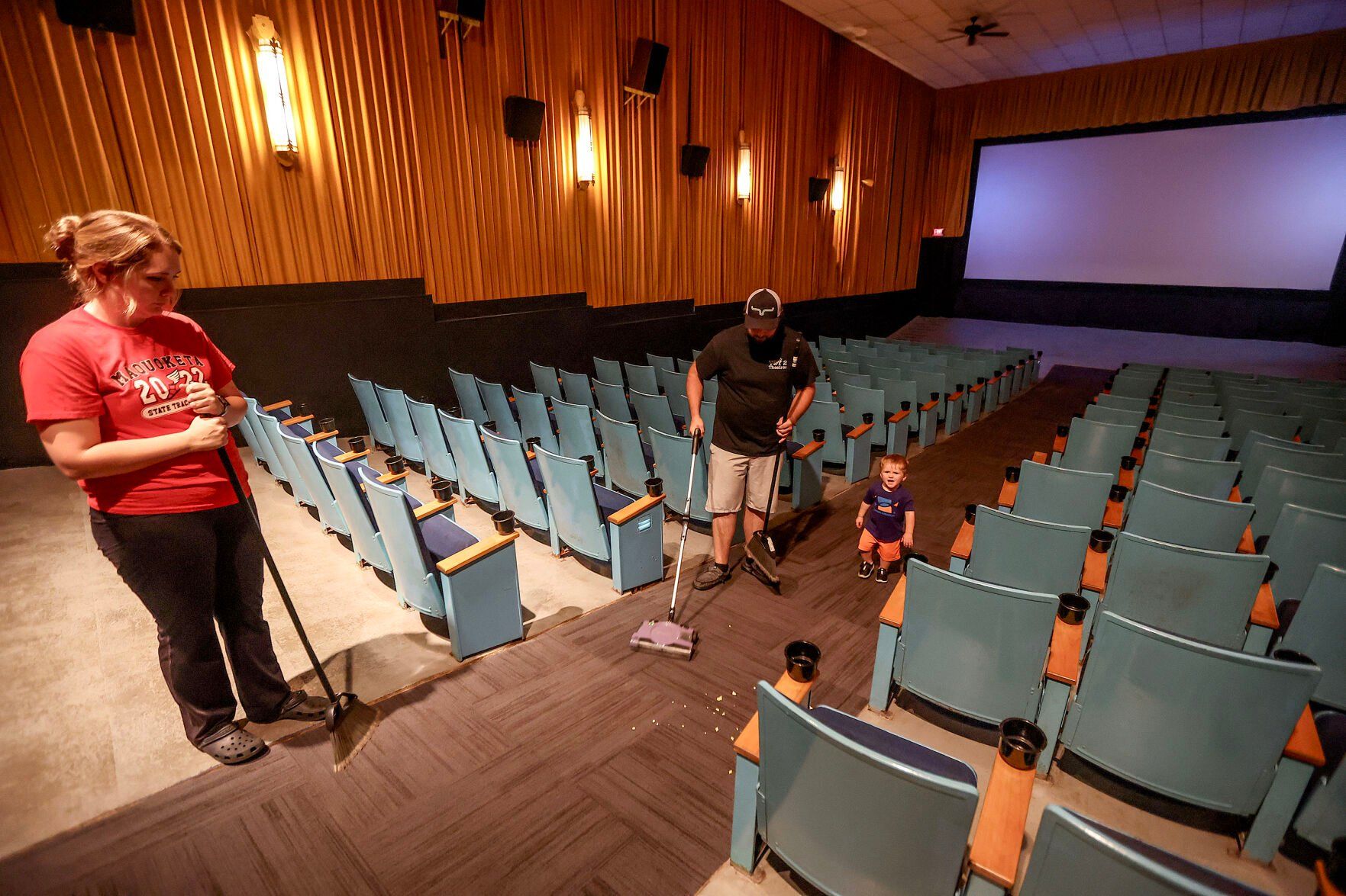 Owners Taylor Casel (left), of Maquoketa, Iowa, along with her husband Tyler Linden and son, Hudson, 1, clean up after a showing at the Voy Theater on Saturday, Aug. 17, 2024.    PHOTO CREDIT: Dave Kettering