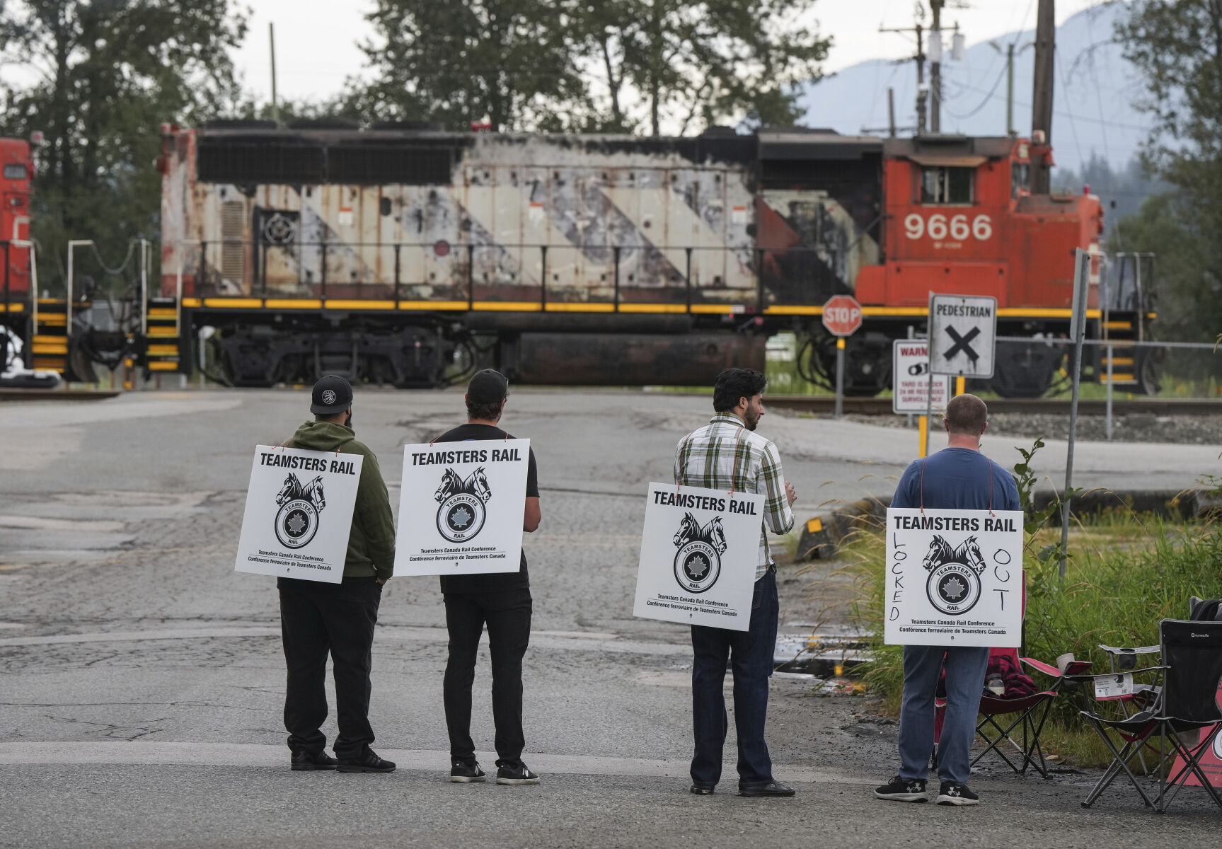 Locked out Canadian National Rail workers stand at a picket line as locomotives are moved by management at CN Rail