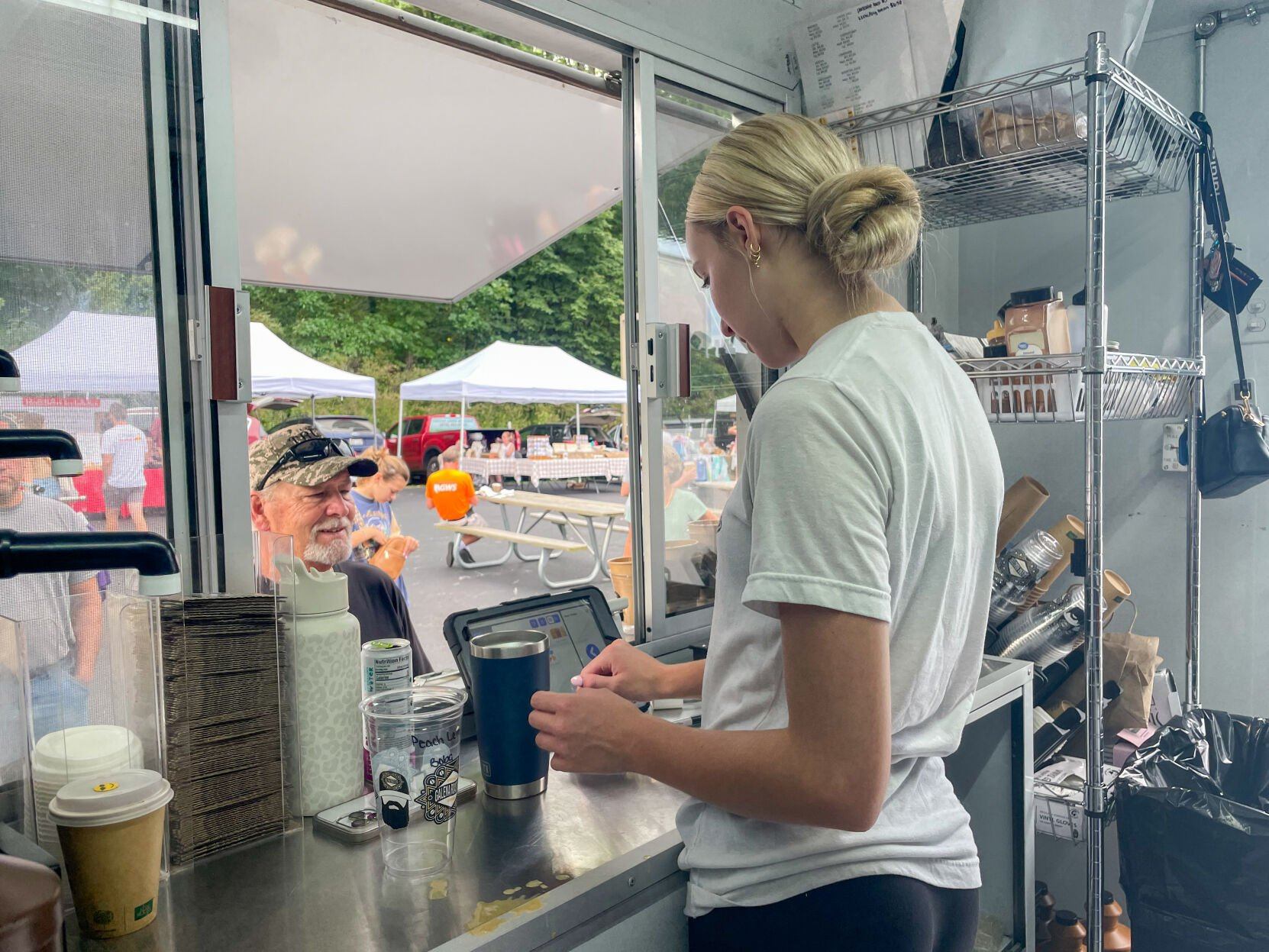 Jayme Frank takes customers’ orders in the Galena Roasters coffee truck at The Galena Territory Farmers Market.    PHOTO CREDIT: Elizabeth Kelsey
Telegraph Herald