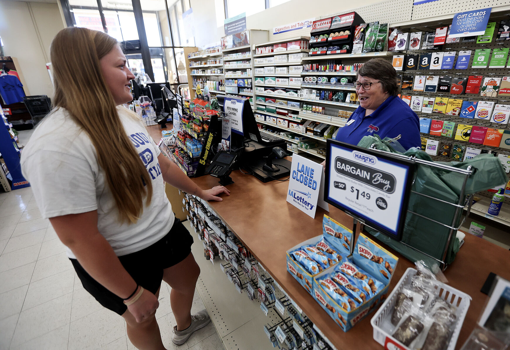 Hartig Drug employee Sue Erickson (right) chats with customer Courtney Olson, of Dubuque, at the Locust Street branch.    PHOTO CREDIT: Dave Kettering