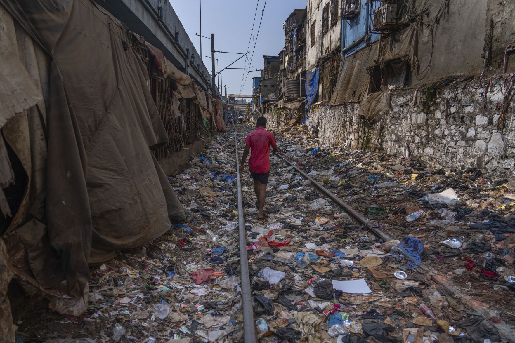 <p>FILE - A man walks on a railway track littered with plastic and other waste materials on Earth Day in Mumbai, India, April 22, 2024. (AP Photo/Rafiq Maqbool, File)</p>   PHOTO CREDIT: Rafiq Maqbool - staff, ASSOCIATED PRESS