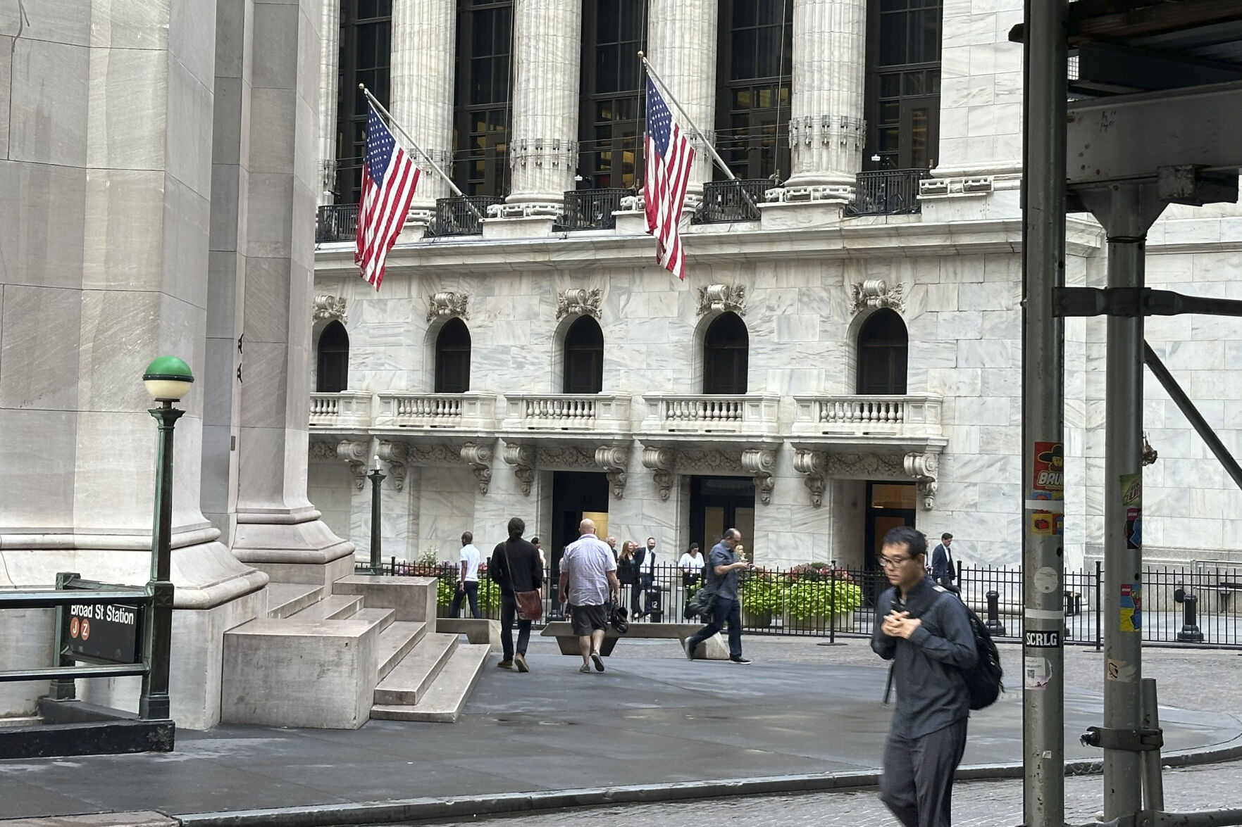 FILE - People pass the New York Stock Exchange, at rear, on Aug. 27, 2024, in New York. (AP Photo/Peter Morgan, File)    PHOTO CREDIT: Associated Press