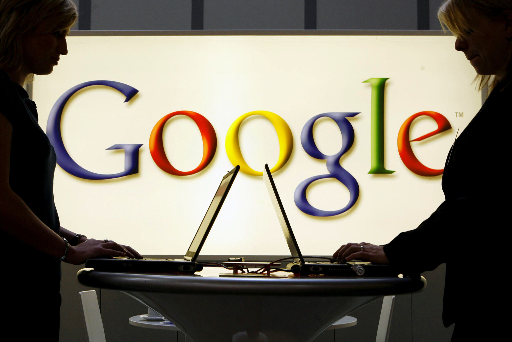 <p>FILE - In this April 17, 2007 file photo, exhibitors work on laptop computers in front of an illuminated sign of the Google logo at the industrial fair Hannover Messe in Hanover, Germany. (AP Photo/Jens Meyer, File)</p>   PHOTO CREDIT: Jens Meyer 