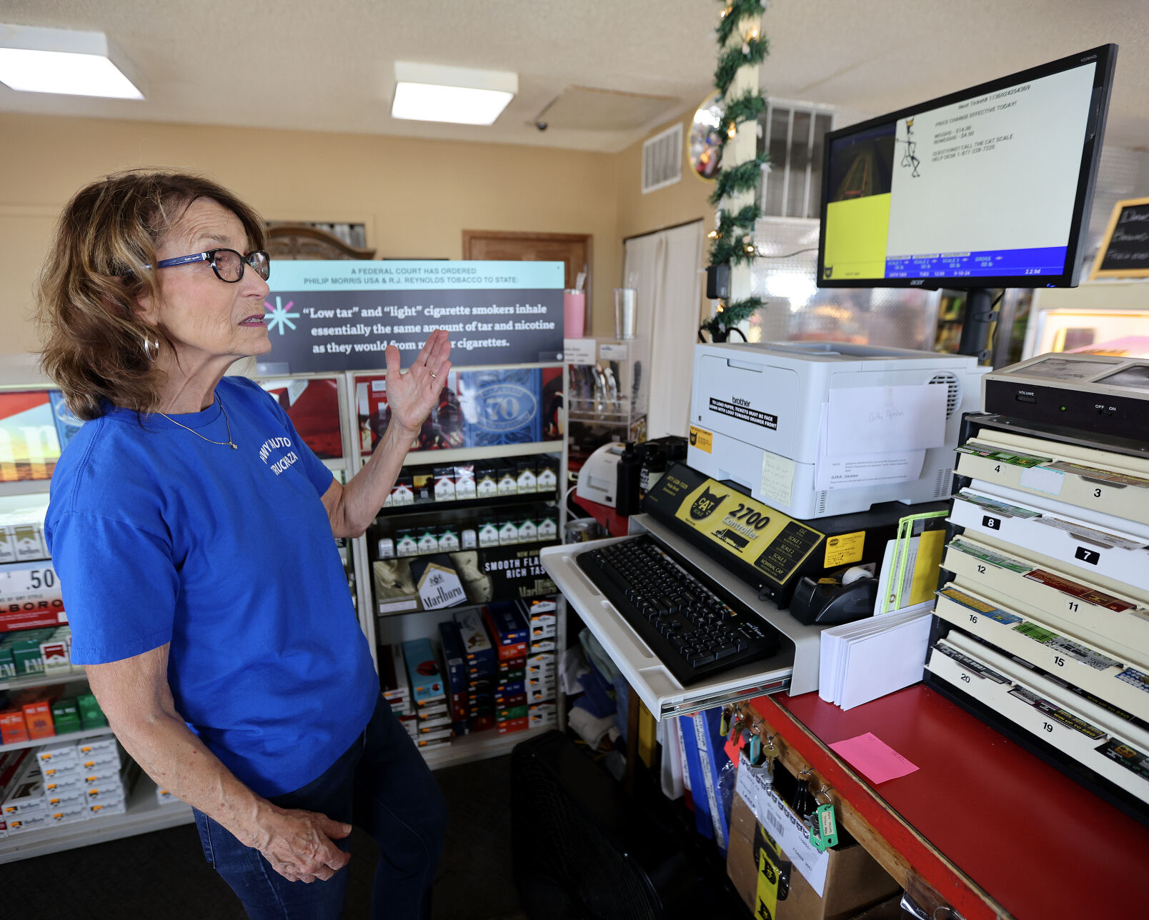 Margie White, co-owner of the Highway 20 Auto/Truck Plaza just outside Dubuque, shows the CAT scale (shown at right) that is used by truck drivers.    PHOTO CREDIT: Dave Kettering