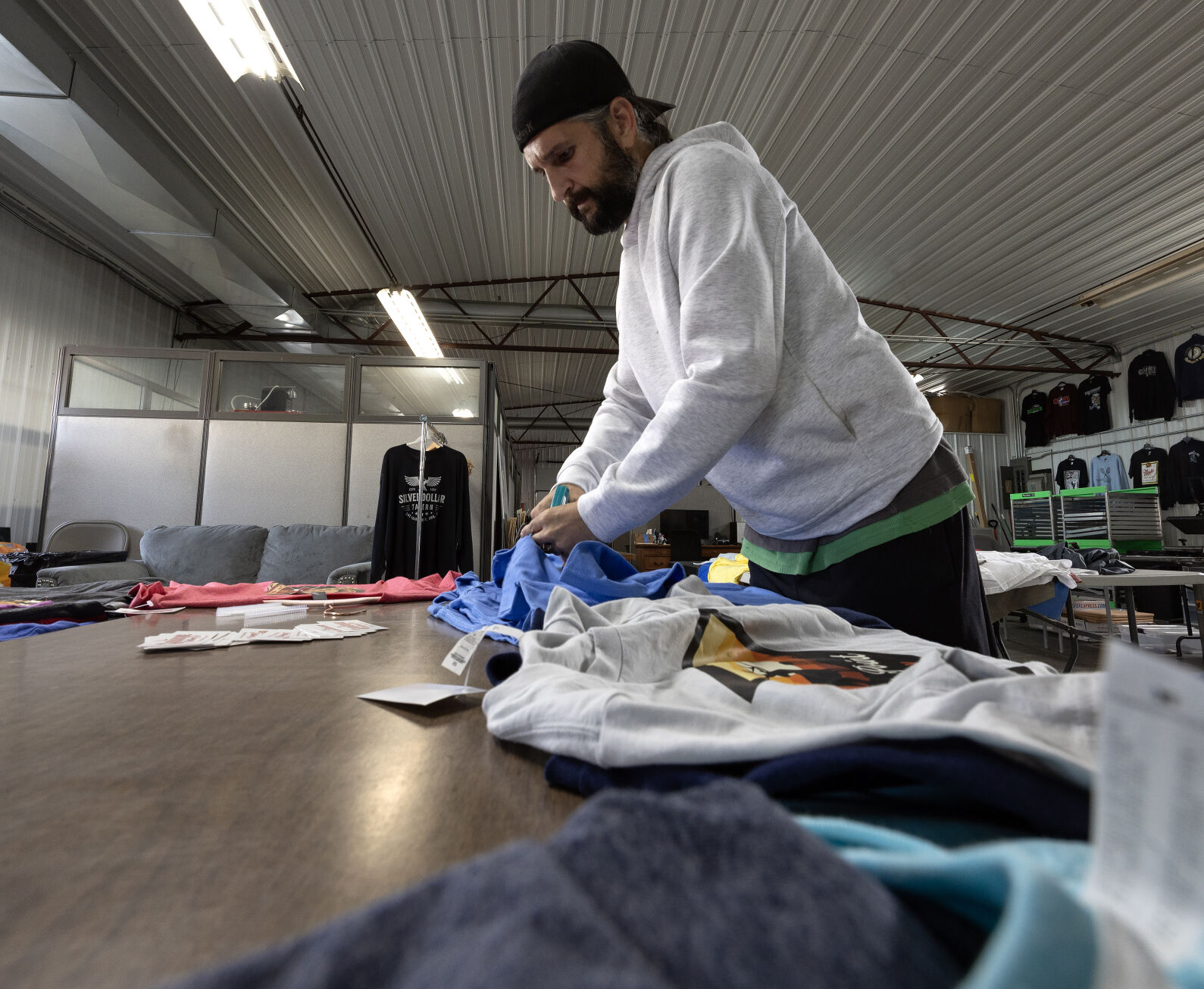 Folstad tags shirts at Dubuque Clothing Co. on Wednesday.    PHOTO CREDIT: Stephen Gassman