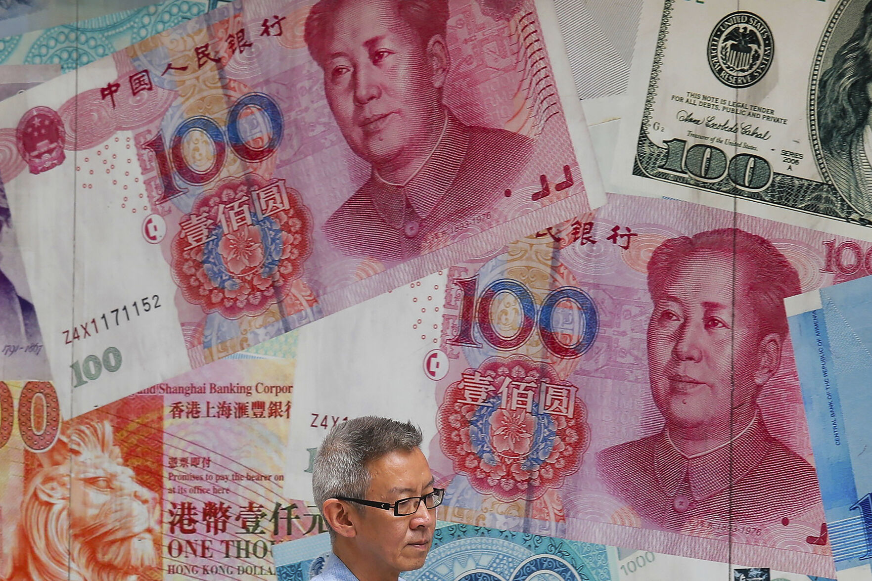 <p>FILE - A man walks by a money exchange shop decorated with Chinese yuan banknotes and other countries currency banknotes at Central, a business district in Hong Kong, Aug. 6, 2019. (AP Photo/Kin Cheung, File)</p>   PHOTO CREDIT: Kin Cheung - staff, ASSOCIATED PRESS