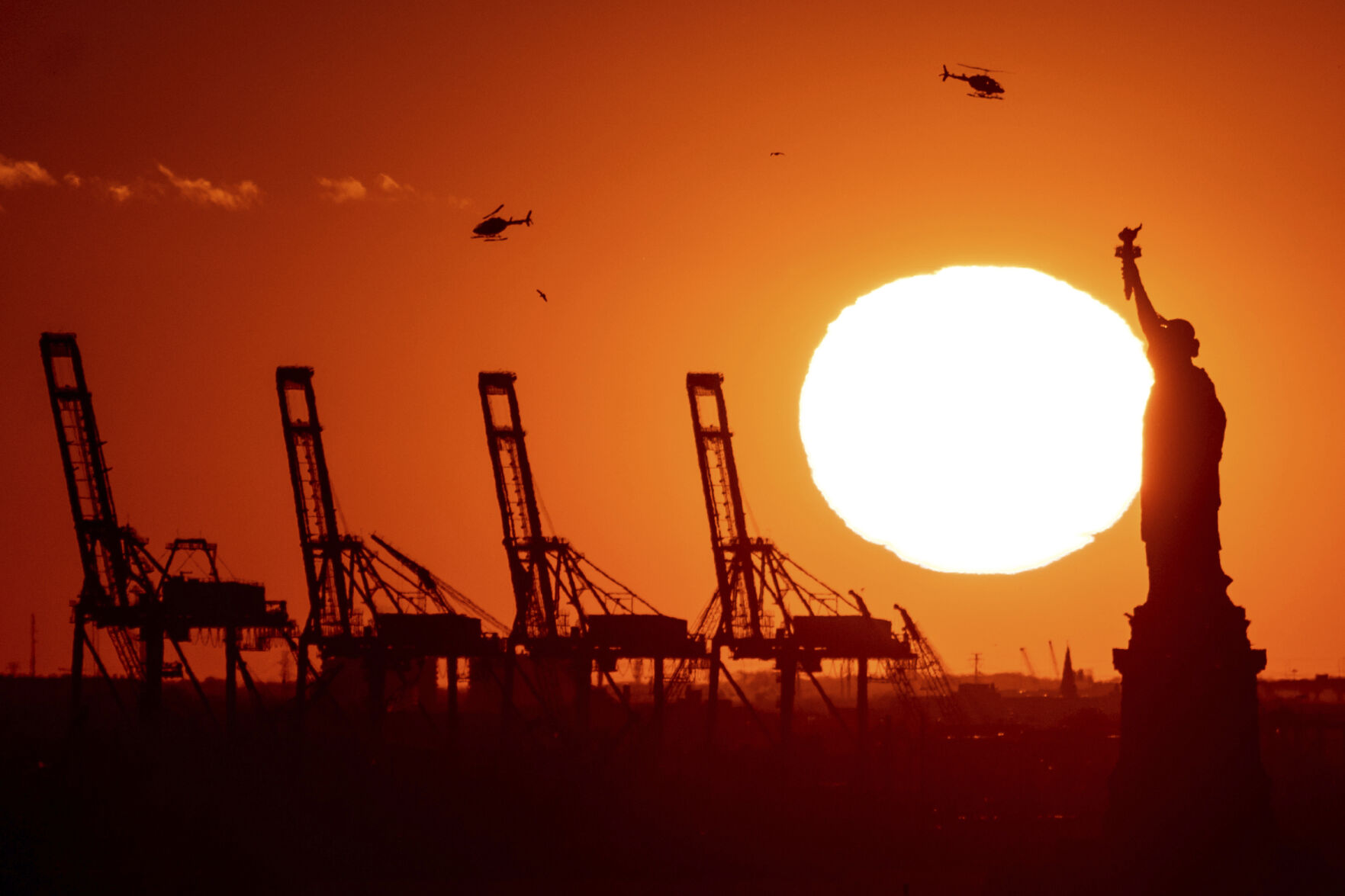 <p>FILE - Cranes at the Port of New York and New Jersey appear behind the Statue of Liberty, Nov. 20, 2022, in a photo taken from New York. (AP Photo/Julia Nikhinson, File)</p>   PHOTO CREDIT: Julia Nikhinson 