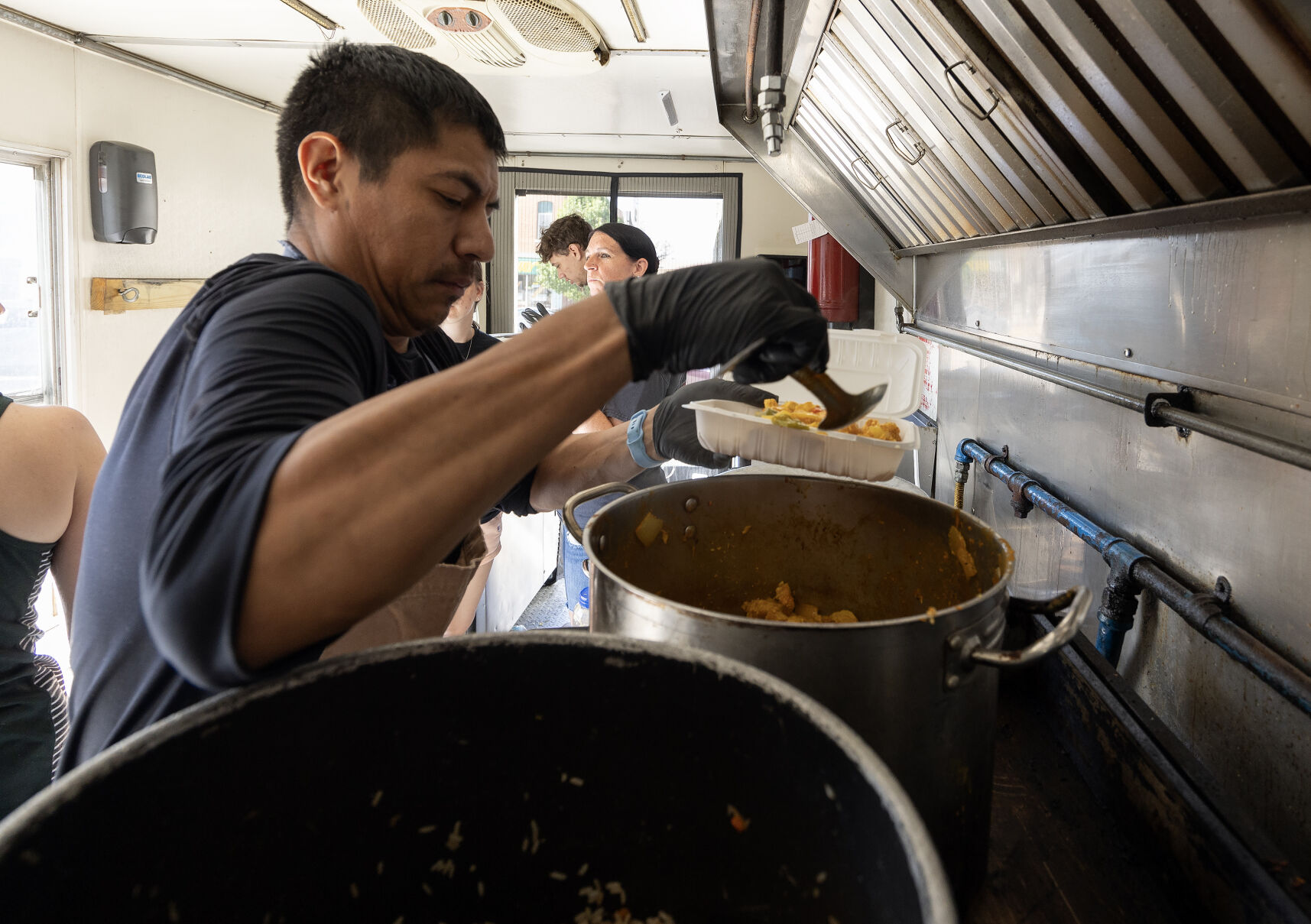 Owner Tomas Weber dishes up a meal at Rice is Nice food truck while parked in Cuba City, Wis., on Saturday.    PHOTO CREDIT: Stephen Gassman