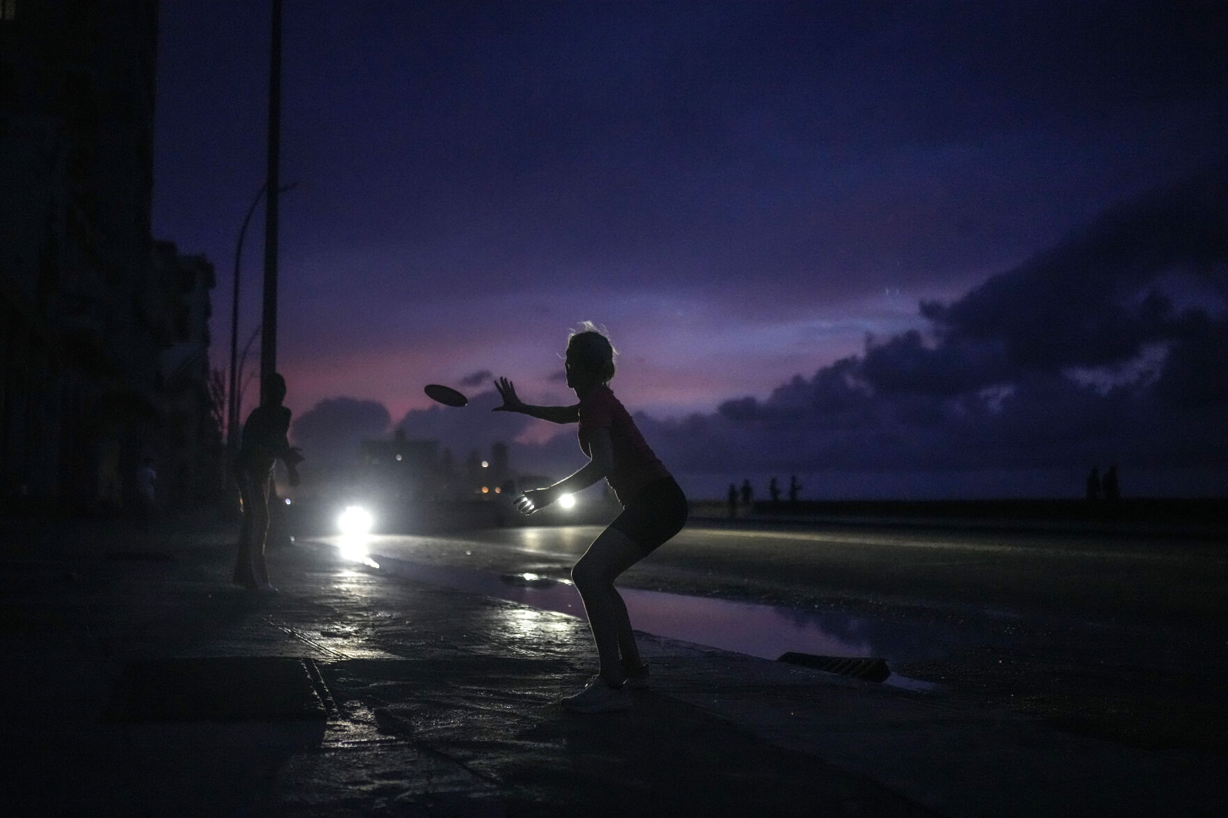 <p>A woman prepares to catch a tossed frisbee during a massive blackout after a major power plant failed in Havana, Cuba, Friday, Oct. 18, 2024. (AP Photo/Ramon Espinosa)</p>   PHOTO CREDIT: Ramon Espinosa - staff, ASSOCIATED PRESS