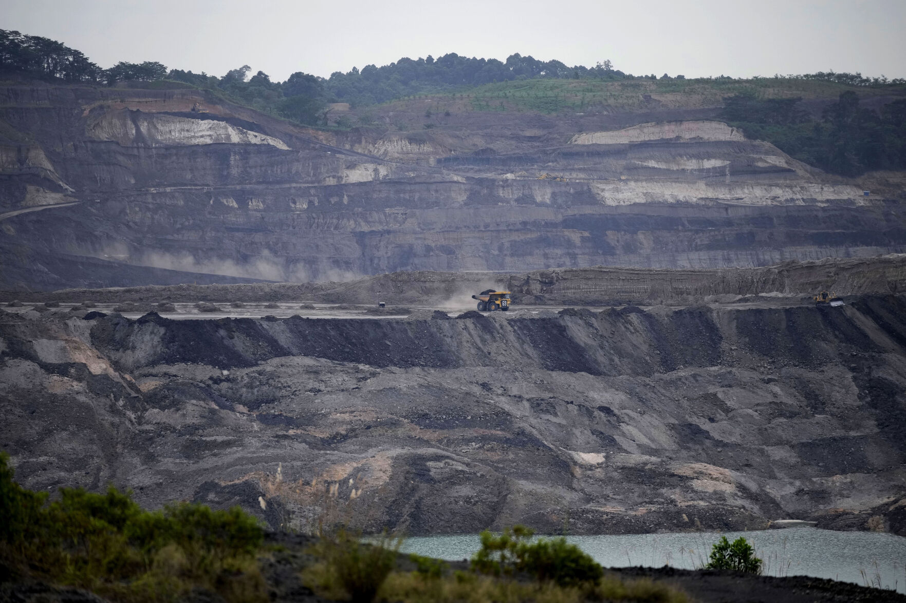 <p>FILE - A dump truck carrying coal navigates its way near a coal mining pit in Sanga-Sanga, East Kalimantan, Indonesia, Dec. 20, 2022. (AP Photo/Dita Alangkara, File)</p>   PHOTO CREDIT: Dita Alangkara