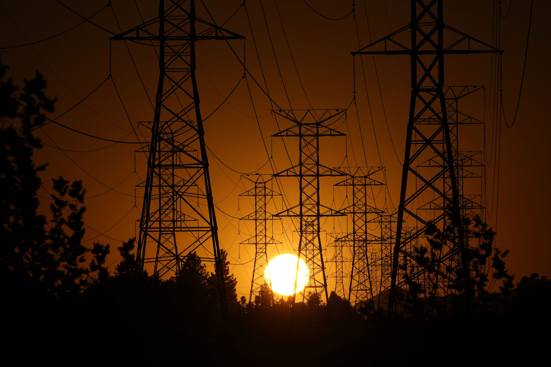 <p>FILE - The sun sets behind high tension power lines on Sept. 23, 2024, in the Porter Ranch section of Los Angeles. (AP Photo/Mark J. Terrill, File)</p>   PHOTO CREDIT: Mark J. Terrill 