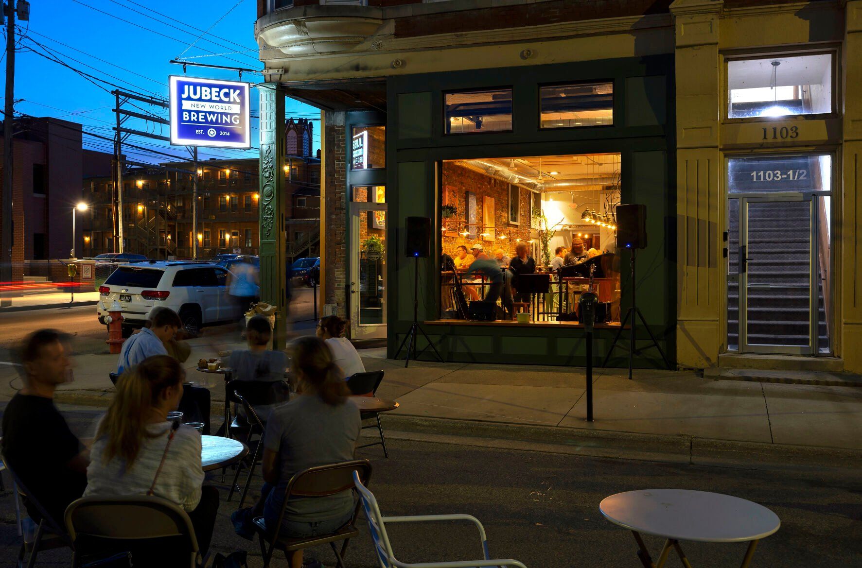 A crowd sits on Iowa Street listening to open mic night at Jubeck New World Brewing.    PHOTO CREDIT: File photo