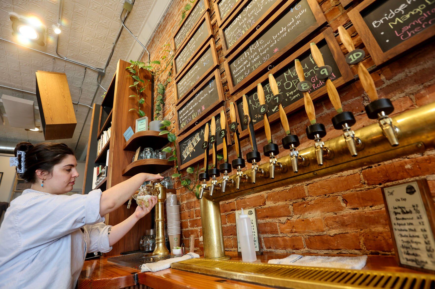 Shea Malloy pulls a fresh crafted beer for a customer at Jubeck New World Brewing.    PHOTO CREDIT: File photo