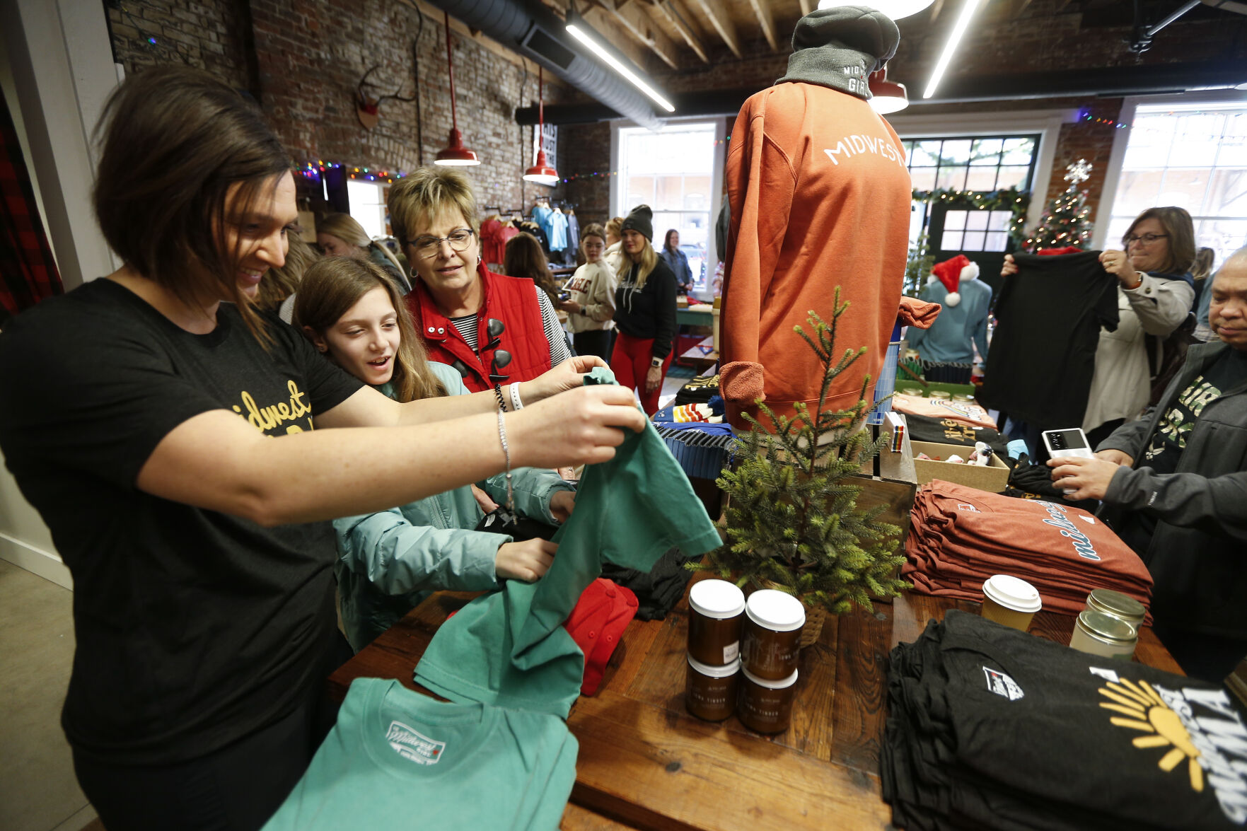 Julie Day (left), of Clive, Iowa, along with her daughter, Bridget, 10, and mother Doris Ries, of Dubuque, browse at The Midwest Girl during Small Business Saturday.    PHOTO CREDIT: File photo