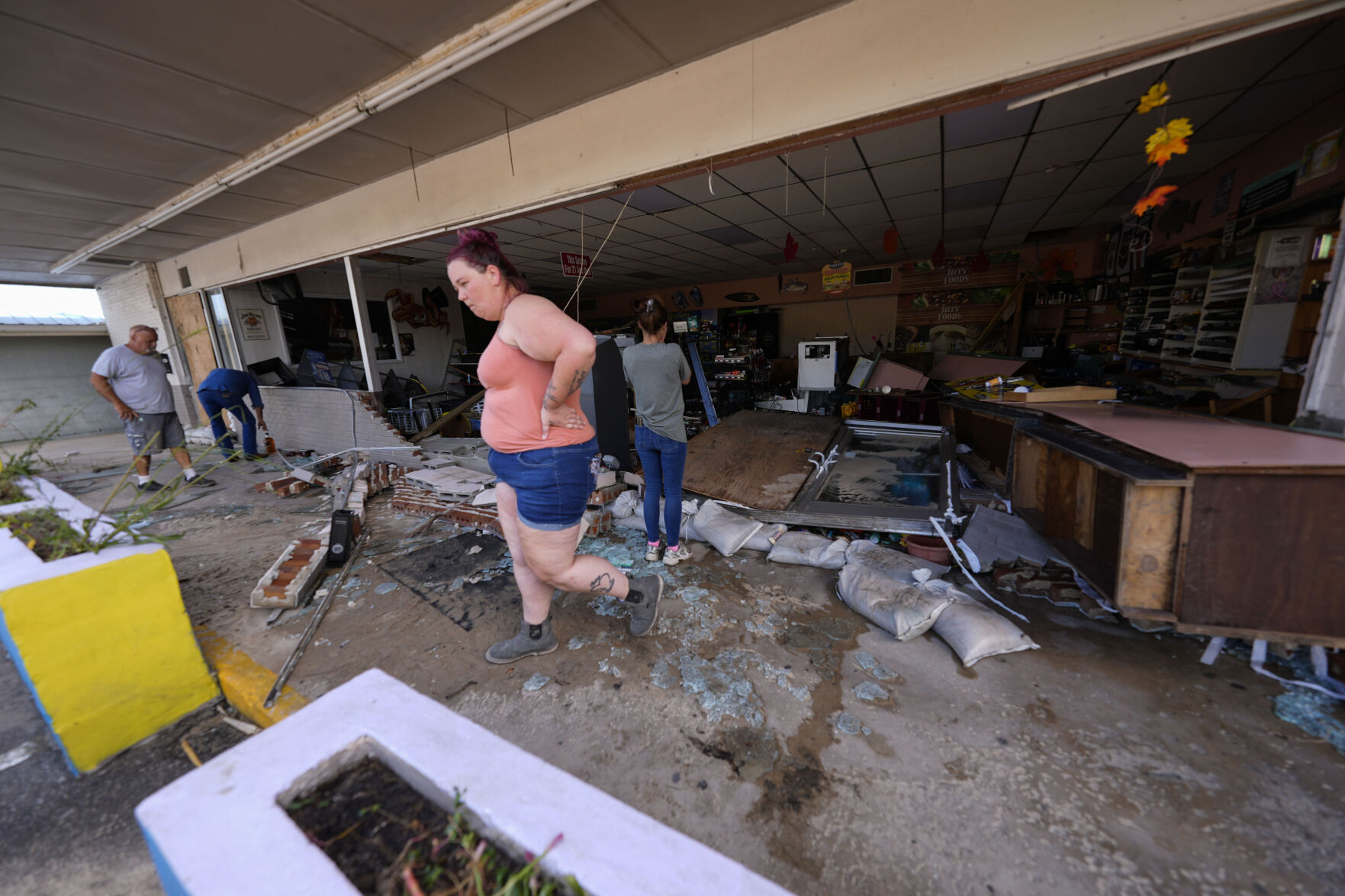 <p>FILE - Kegan Ward, assistant manager of Swami Spirits, walks through debris of the damaged store in the aftermath of Hurricane Helene, in Cedar Key, Fla., on Sept. 27, 2024. (AP Photo/Gerald Herbert, File)</p>   PHOTO CREDIT: Gerald Herbert - staff, ASSOCIATED PRESS