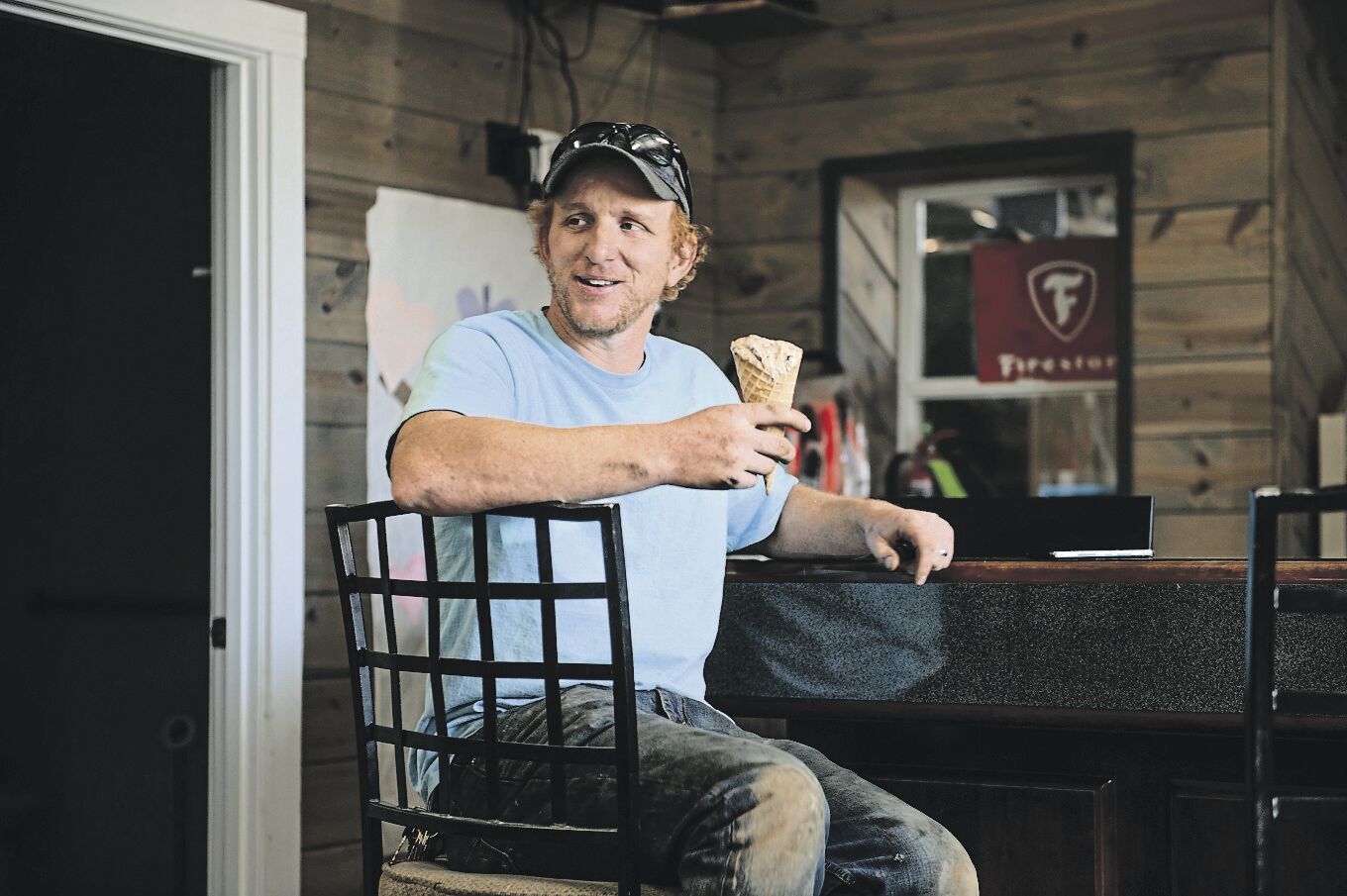 Mechanic Matt Delaney, 34, takes a moment away from fixing a car at Delaney’s Auto Repair to enjoy a frozen treat from Delaney’s Ice Cream Shoppe in Farley, Iowa.    PHOTO CREDIT: Dave LaBelle • Staff Photo