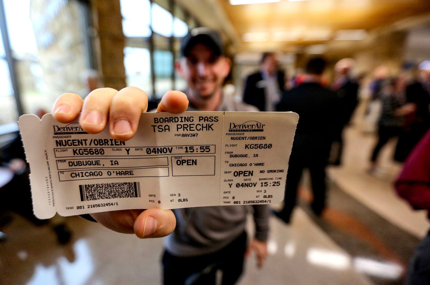 Brien Nugent, of Dubuque, holds a boarding pass for the first flight out of Dubuque using Denver Air Connection on Monday.    PHOTO CREDIT: Dave Kettering